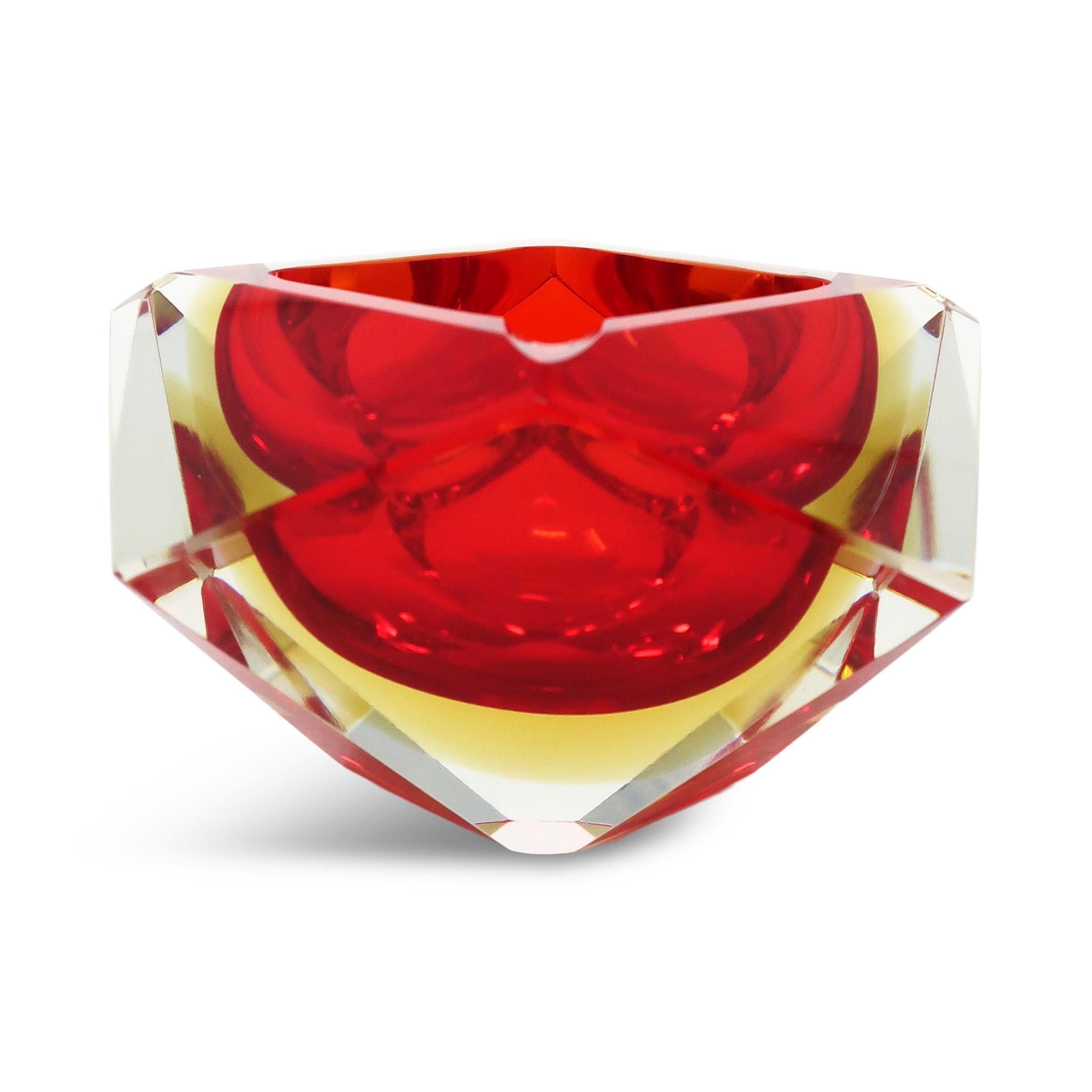 A gorgeous red, yellow, and clear glass ashtray in the style of Flavio Poli for Seguso Vetri d'Arte, Alessandro Mandruzzato, and Vincenzo Nason. The red glass is cased in a band of yellow glass, which is further encased in an angular block of clear