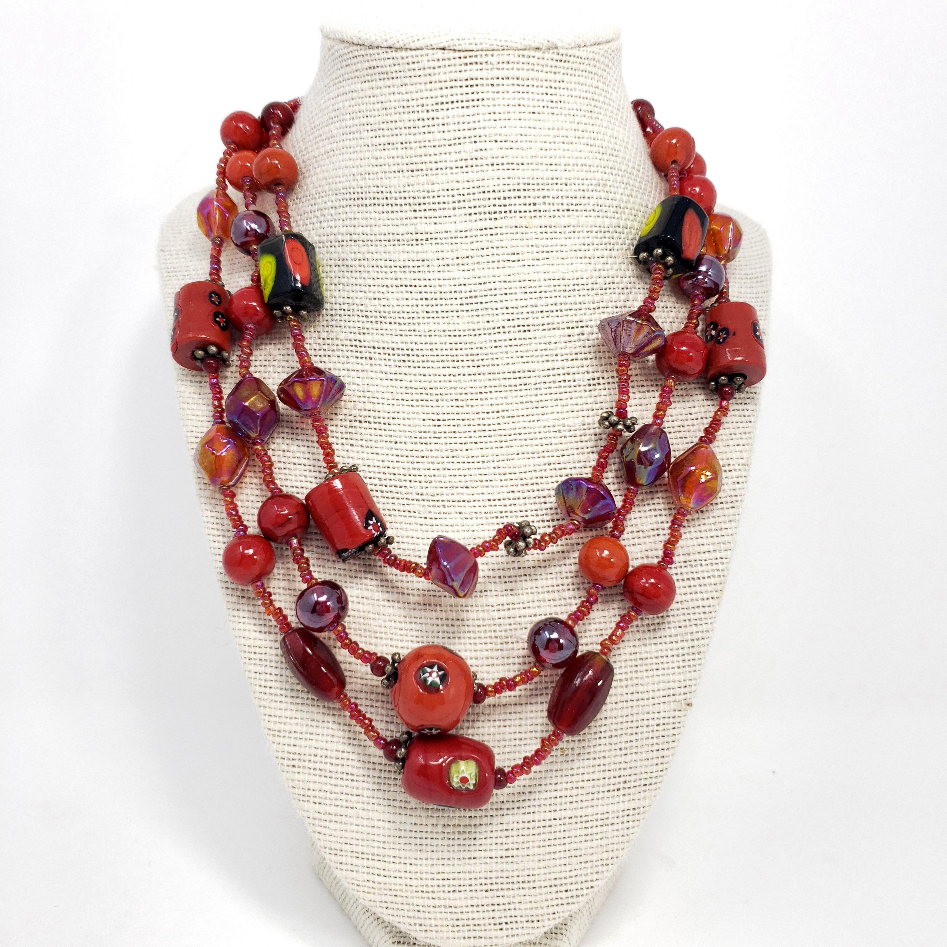 Stylish vintage necklace with three strands of red art-glass beads with an elegant silver-tone hook clasp.

Length: 16.5 to 18.5 inches with extension chain.