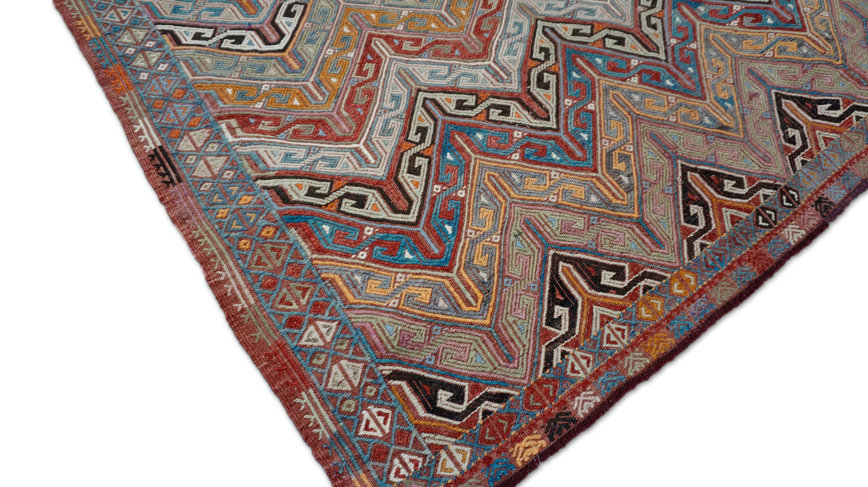 This exceptional vintage handwoven kilim features a mesmerizing zigzag composition with tribal precision and rhythmic complexity. Crafted from hand-spun wool, the rug showcases an intricate field of stepped chevrons—each band interwoven with hooked