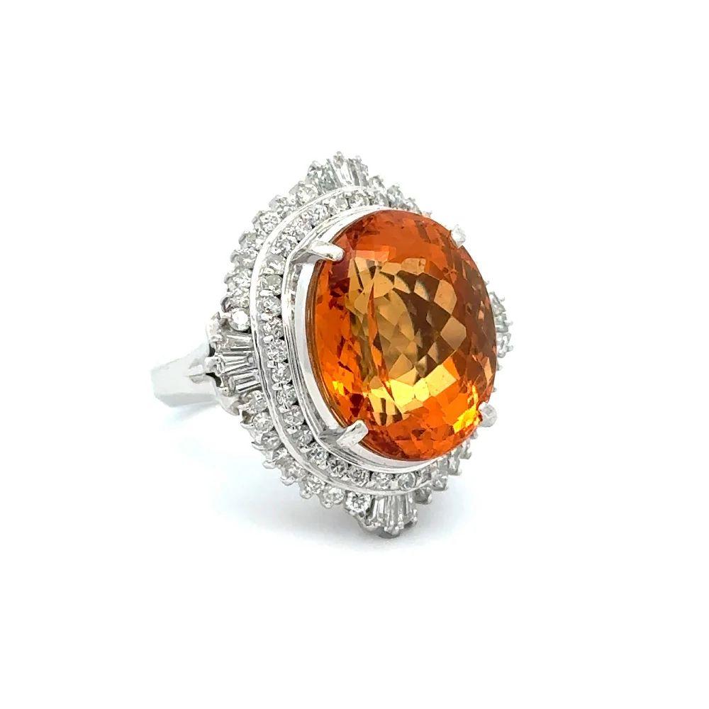 Simply Beautiful! Finely detailed Show Stopper Oval Imperial Topaz and Diamond Statement Platinum Ring. Centering a securely nestled Hand set Oval Imperial Topaz Gemstone GIA, weighing approx. 20.57 Carats. Surrounded by Baguette and Round Brilliant