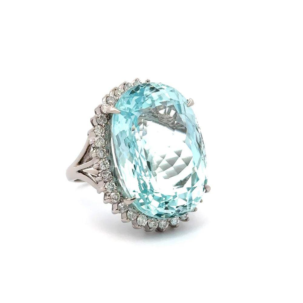 Simply Beautiful! Finely detailed Show Stopper Paraiba Tourmaline and Diamond Statement Platinum Ring. Centering a securely nestled Hand set Oval Neon Blue GIA Paraiba Tourmaline, weighing approx. 34.15 Carats surrounded by Round Brilliant Cut