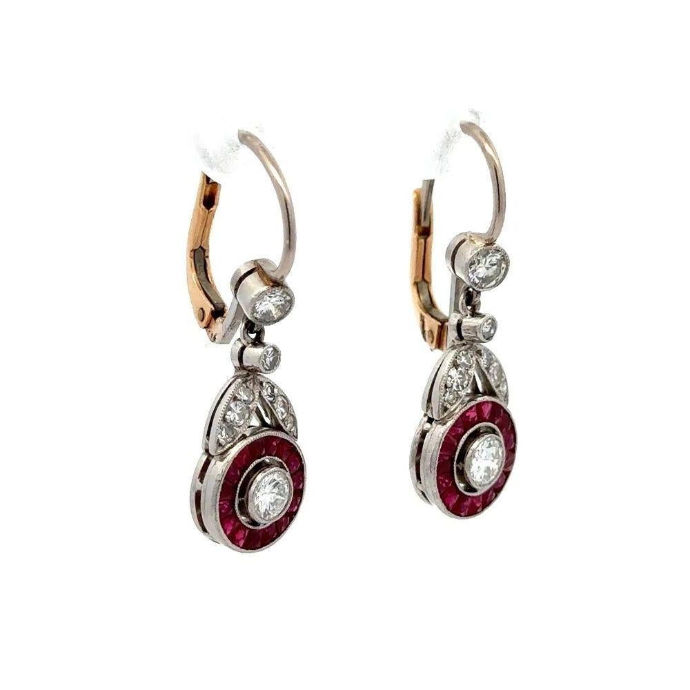 Simply Beautiful! Finely detailed Oscar Worthy Diamond and Red Ruby Halo Platinum Halo Drop Earrings. Hand crafted in Platinum and securely Hand set with 2 Round Brilliant Cut Diamonds, weighing approx. 0.40tcw, Red Rubies, approx. 1.40tcw and side