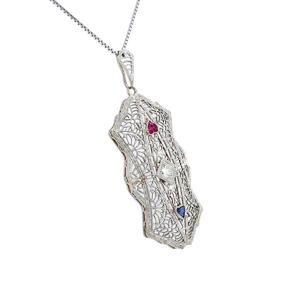 Simply Beautiful! Finely detailed Vintage Show Stopper Rectangular Filigree Diamond and Synthetic Ruby and Sapphire Gold Pendant. Beautifully Hand crafted in 14K White Gold. Center Hand set with a Diamond weighing approx. 0.14 Carat and a Sapphire