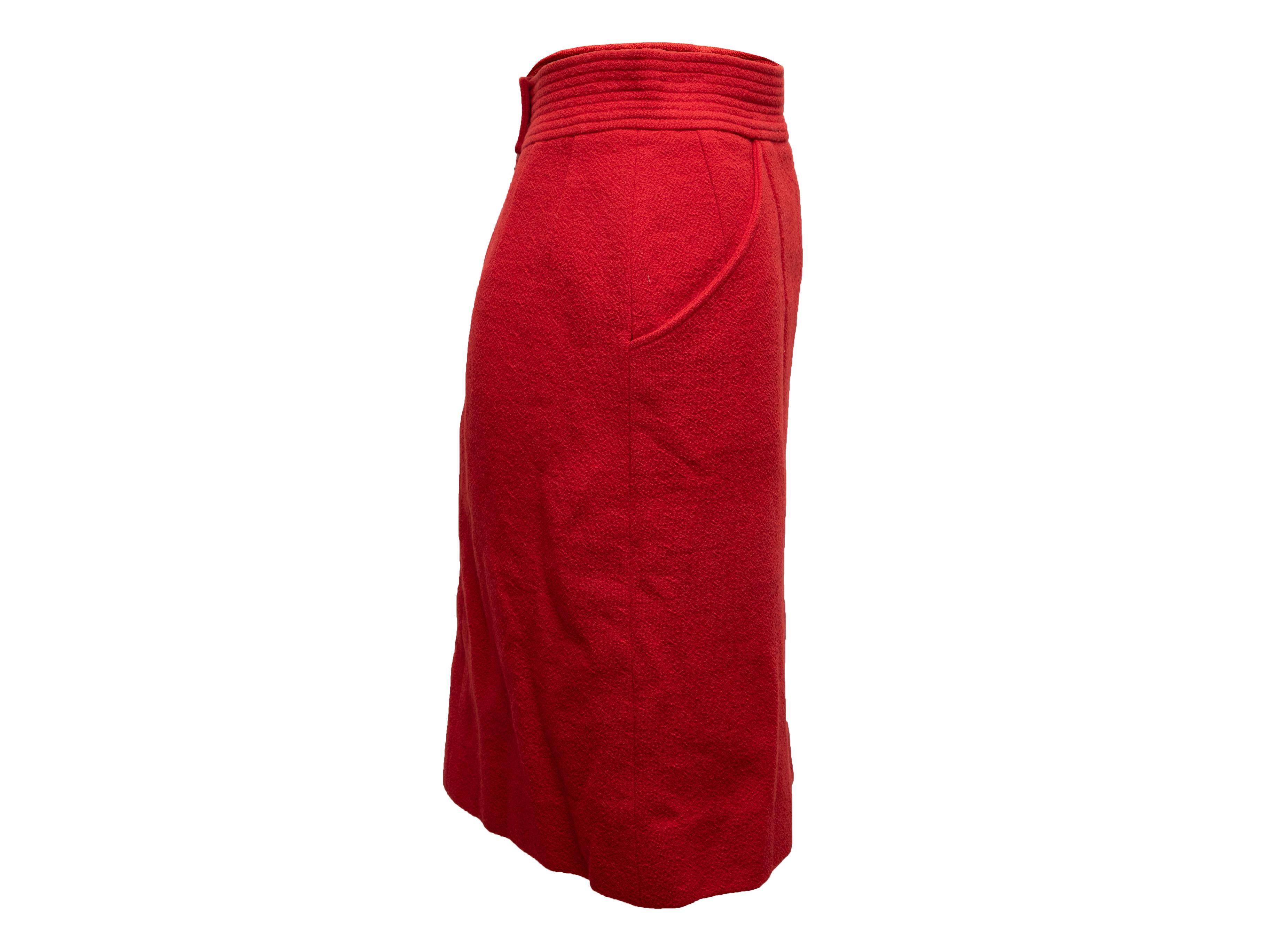 Vintage red wool knee-length pencil skirt by Chanel. Dual hip pockets. Zip and gold-tone button closures at back. 26