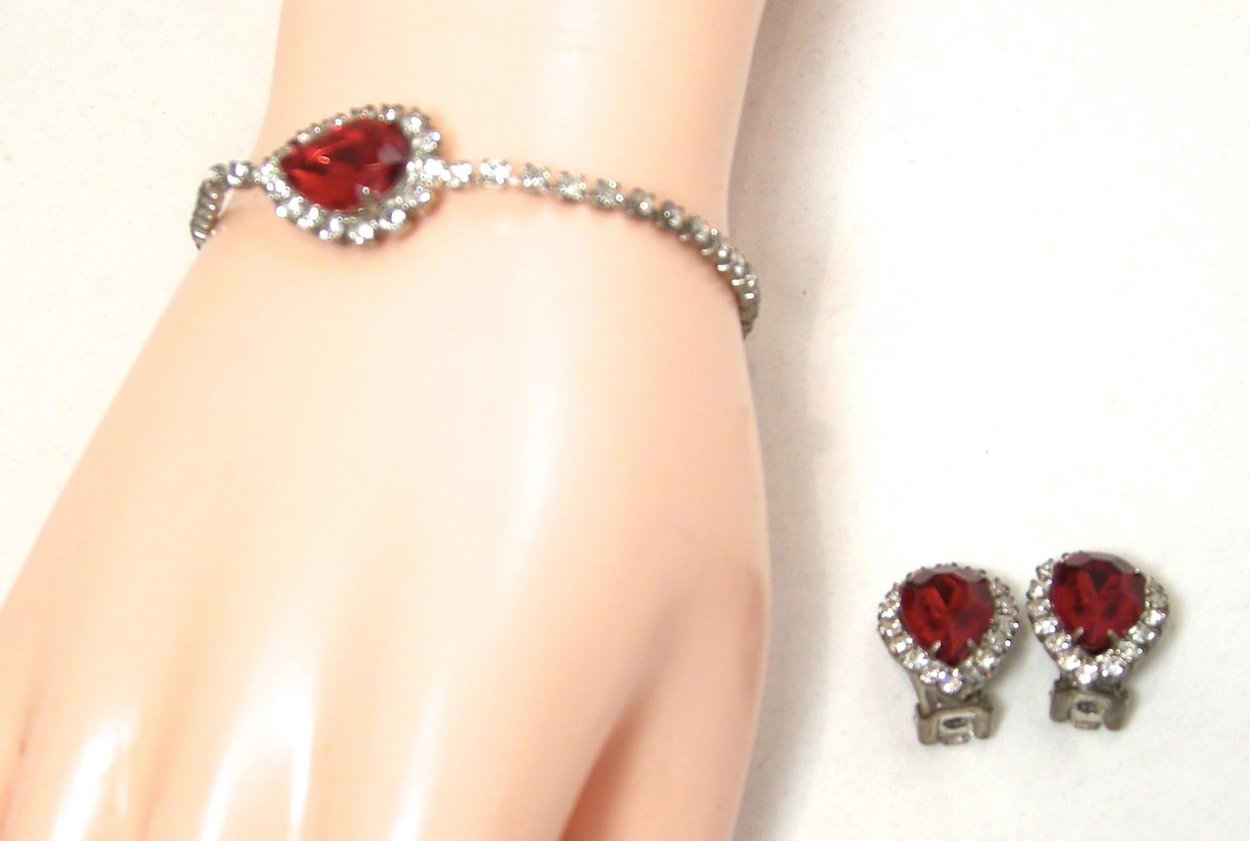 This vintage set includes a matching bracelet & clip earrings.  The bracelet has a center red crystal with clear crystals around the wrist with a fold over clasp.  In The bracelet measures 7-1/2” x 5/8” and the matching clip earrings are 3/4” x 5/8”