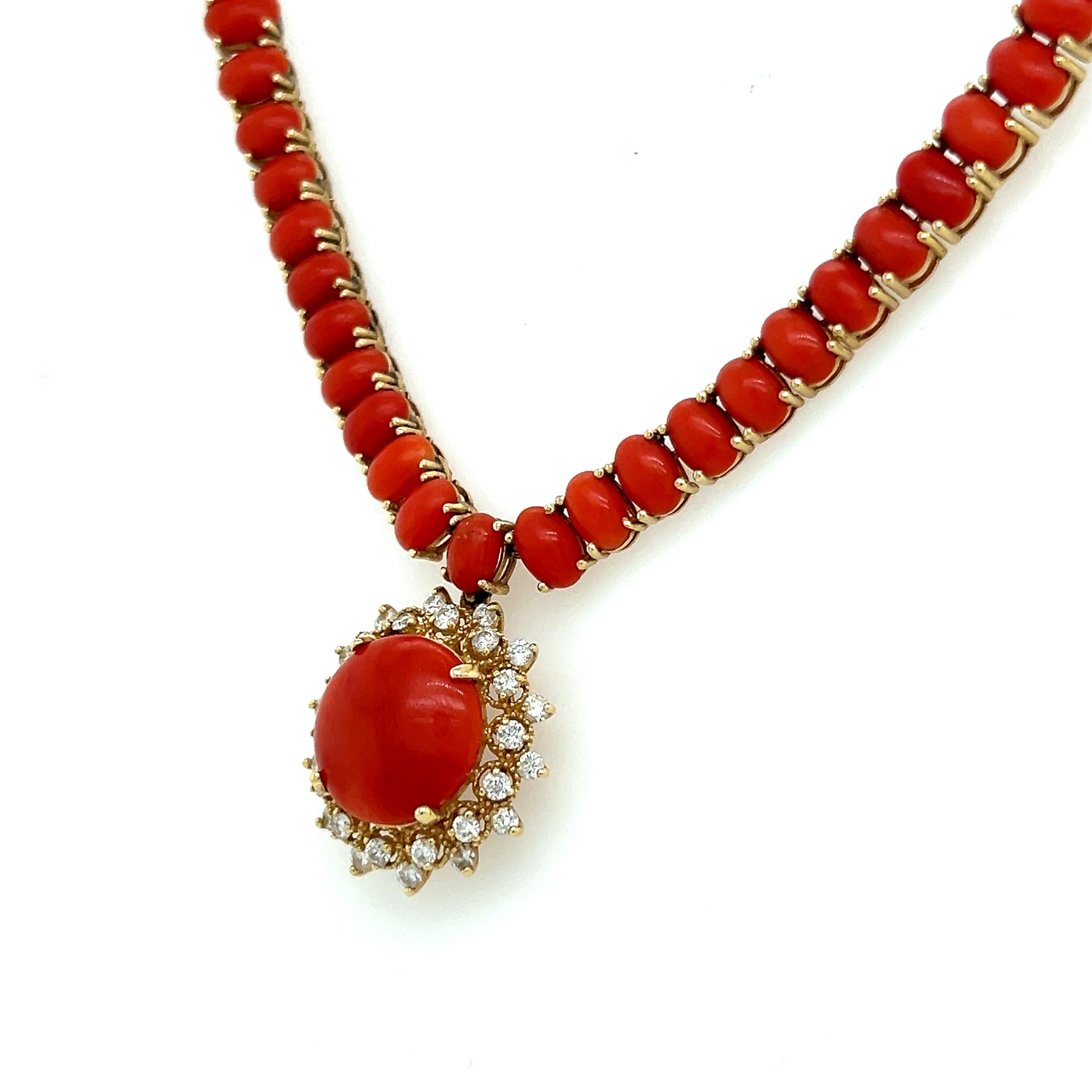 Un elegante collar elaborado en oro amarillo de 14 quilates. El collar exhibe gemas de coral talladas en cabujón que muestran un vibrante y rico color rojo. Las gemas de coral están perfectamente combinadas y se colocan a la perfección en el escote.