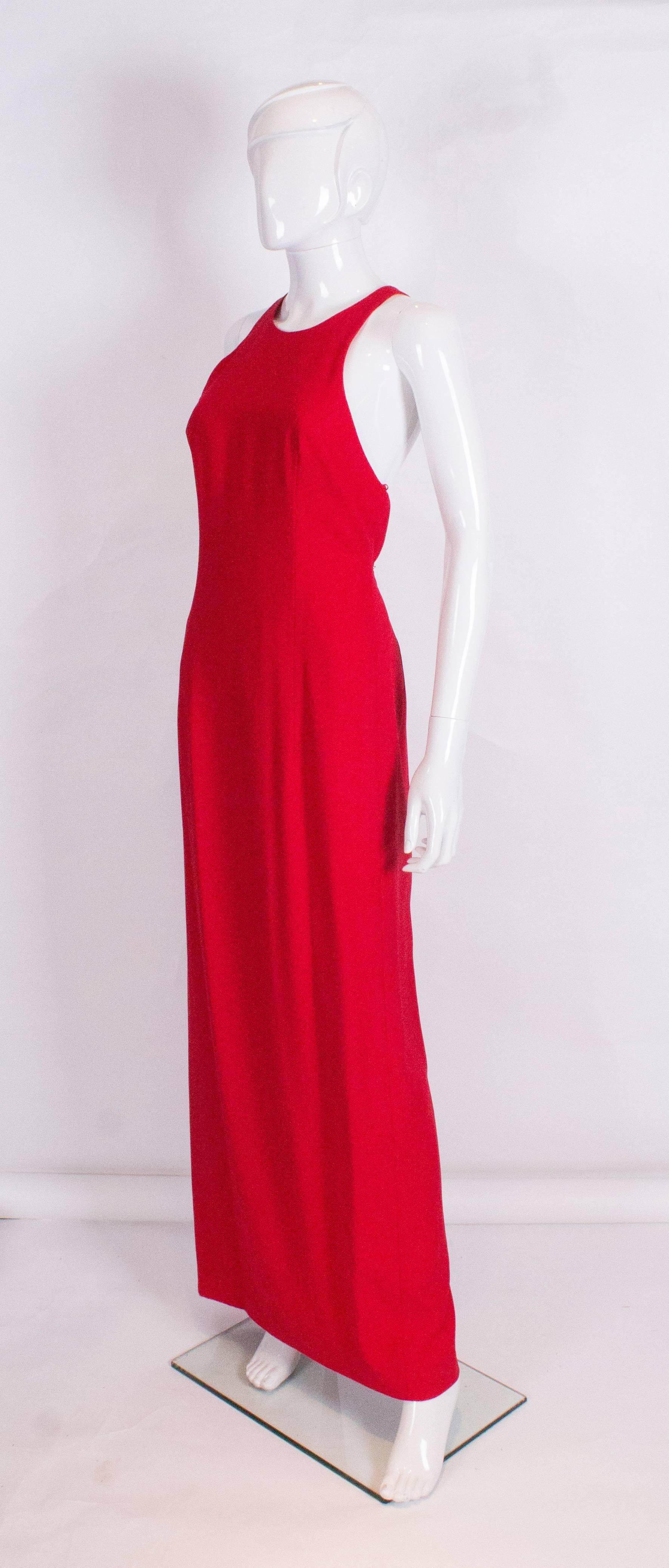 A great red crepe gown, with an attractive cut out design at the back.  The dress has a 24 1/2'' slit at the back , is fully lined and has a low round neckline.