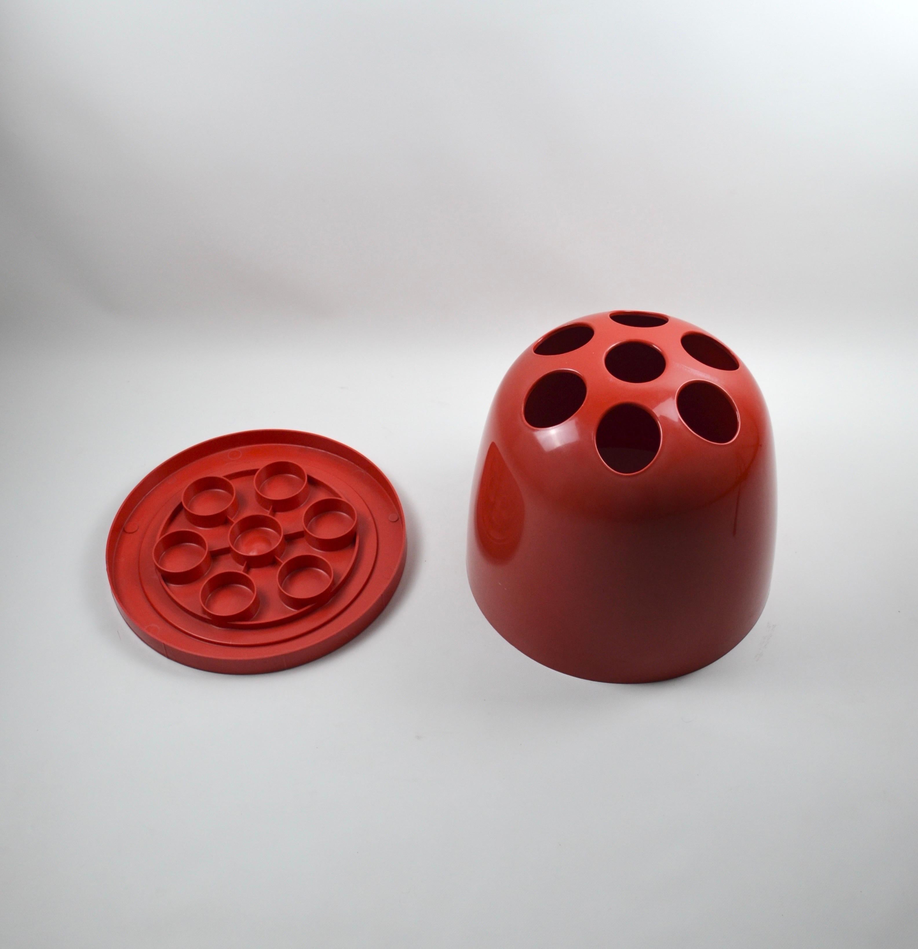 This umbrella stand, model Dedalo, was designed by Emma Gismondi Schweinberger and manufactured by Artemide in 1966. It is made of ABS plastic in the color red.