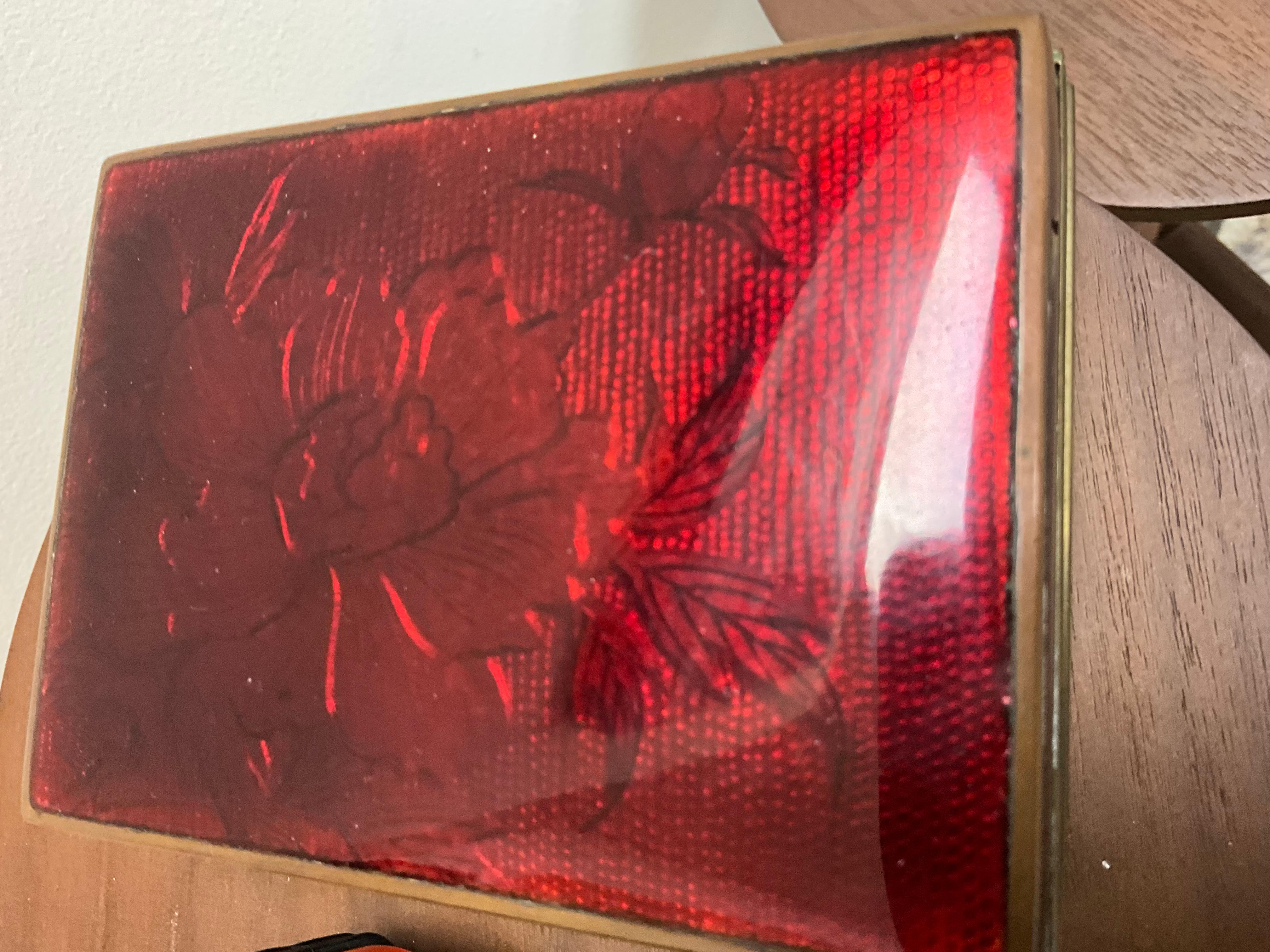 Scatola d'epoca in ottone smaltato rosso - Design floreale dell'inizio e della metà del XX secolo

Scatola d'epoca in ottone e smalto rosso, risalente alla prima metà del XX secolo. Questo pezzo decorativo presenta un bellissimo disegno floreale in