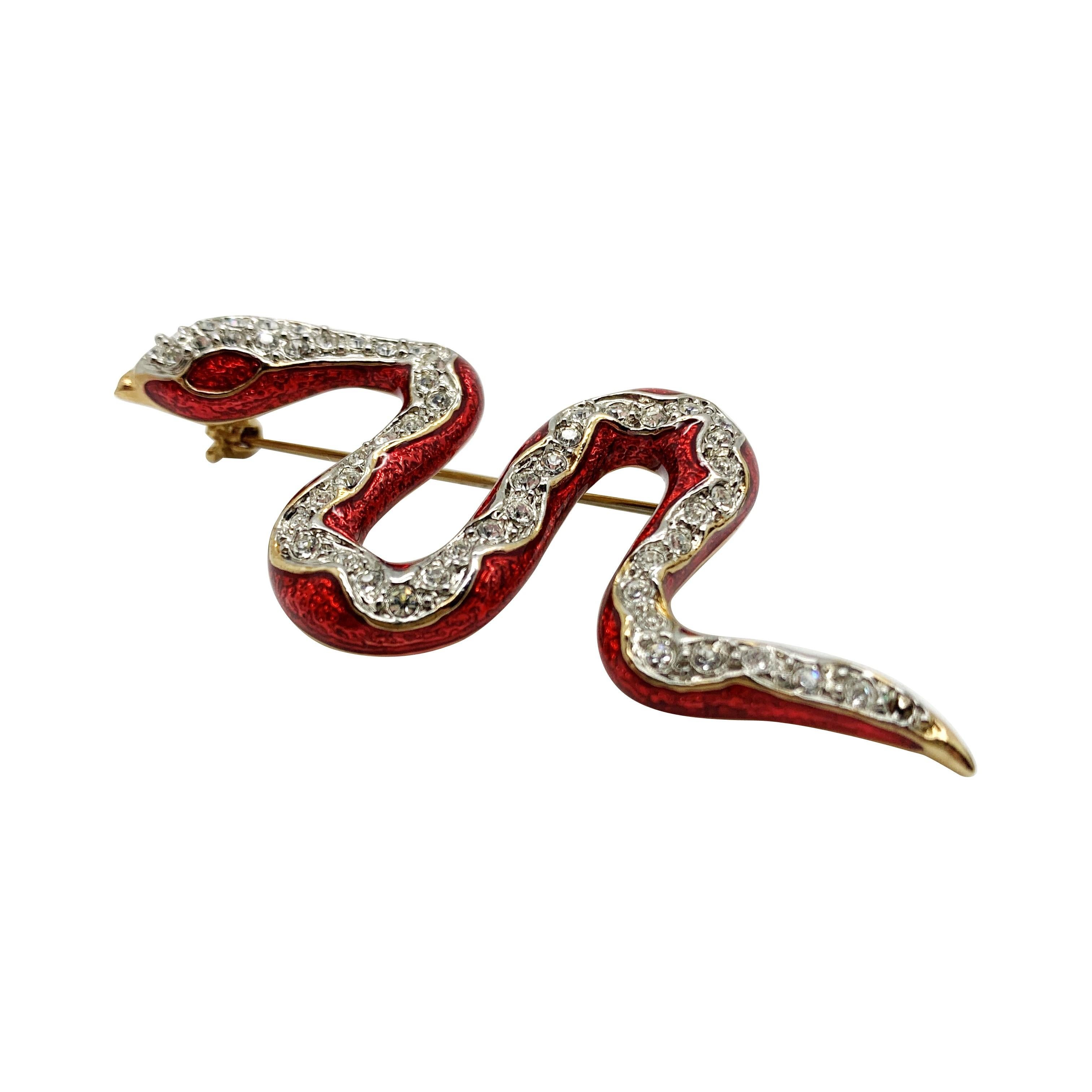 A Vintage Enamel Snake Brooch. Featuring lustrous red enamel with a swathe of crystals.  
Vintage Condition: Very good without damage or noteworthy wear. 
Materials: Gold Plated metal, enamel, glass crystal
Signed: Unsigned
Fastening: Rollover