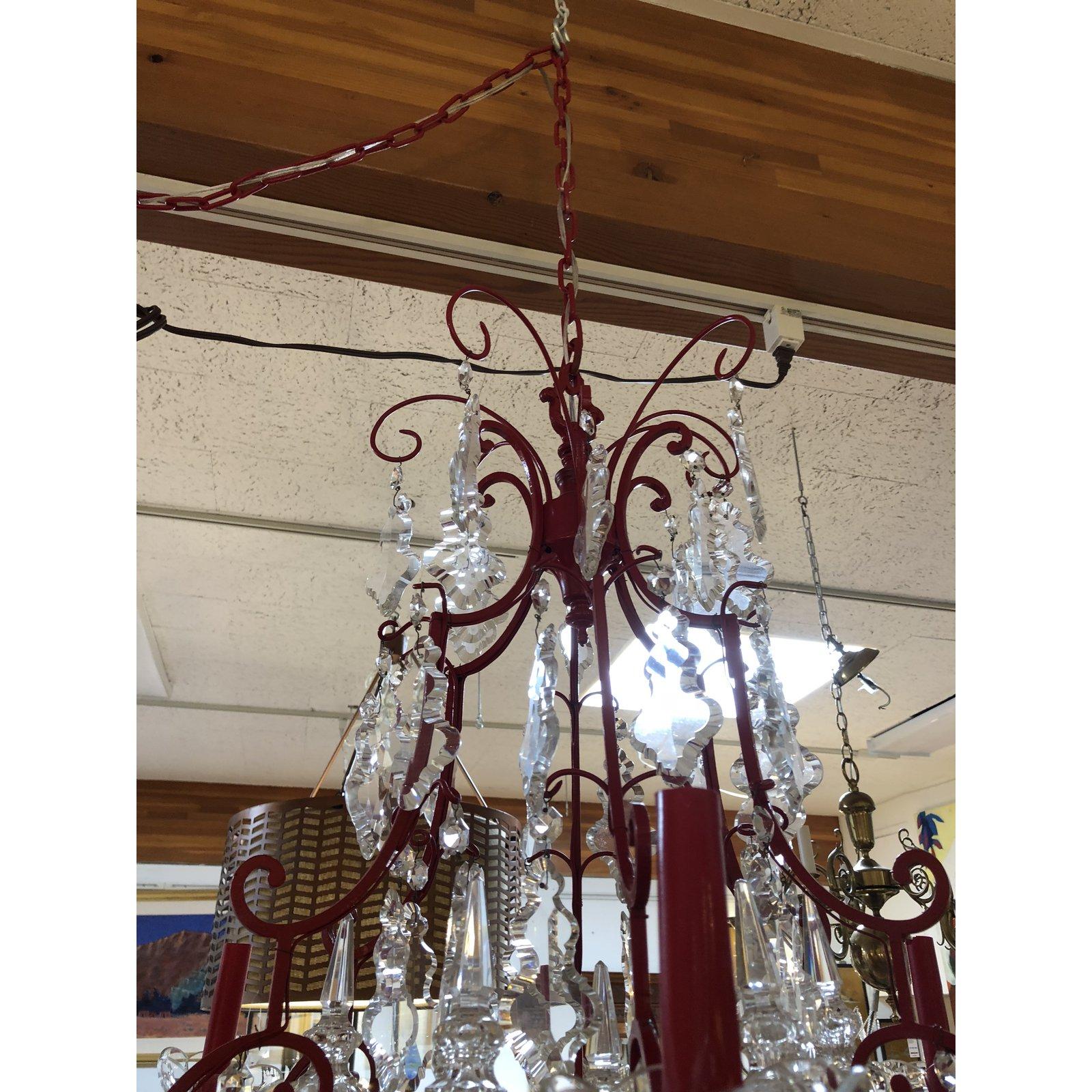 A vintage six-light chandelier. The frame is bronze, which has recently been finished to a fire engine red to create that POP! of color in your space. Cut crystals hang from all tiers of the chandelier. The candelabra candle covers and chain are in