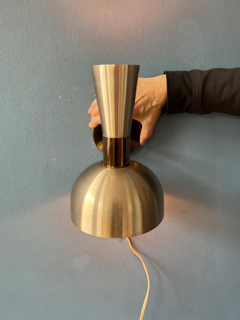 Very hip, small Herda diabolo with red/orange lacquer. The lamp has two lightsources: one in the front and one in the back. The lamp is made out of metal and aluminium. The lamp requires an E27 (standard) lightbulb and currently has an