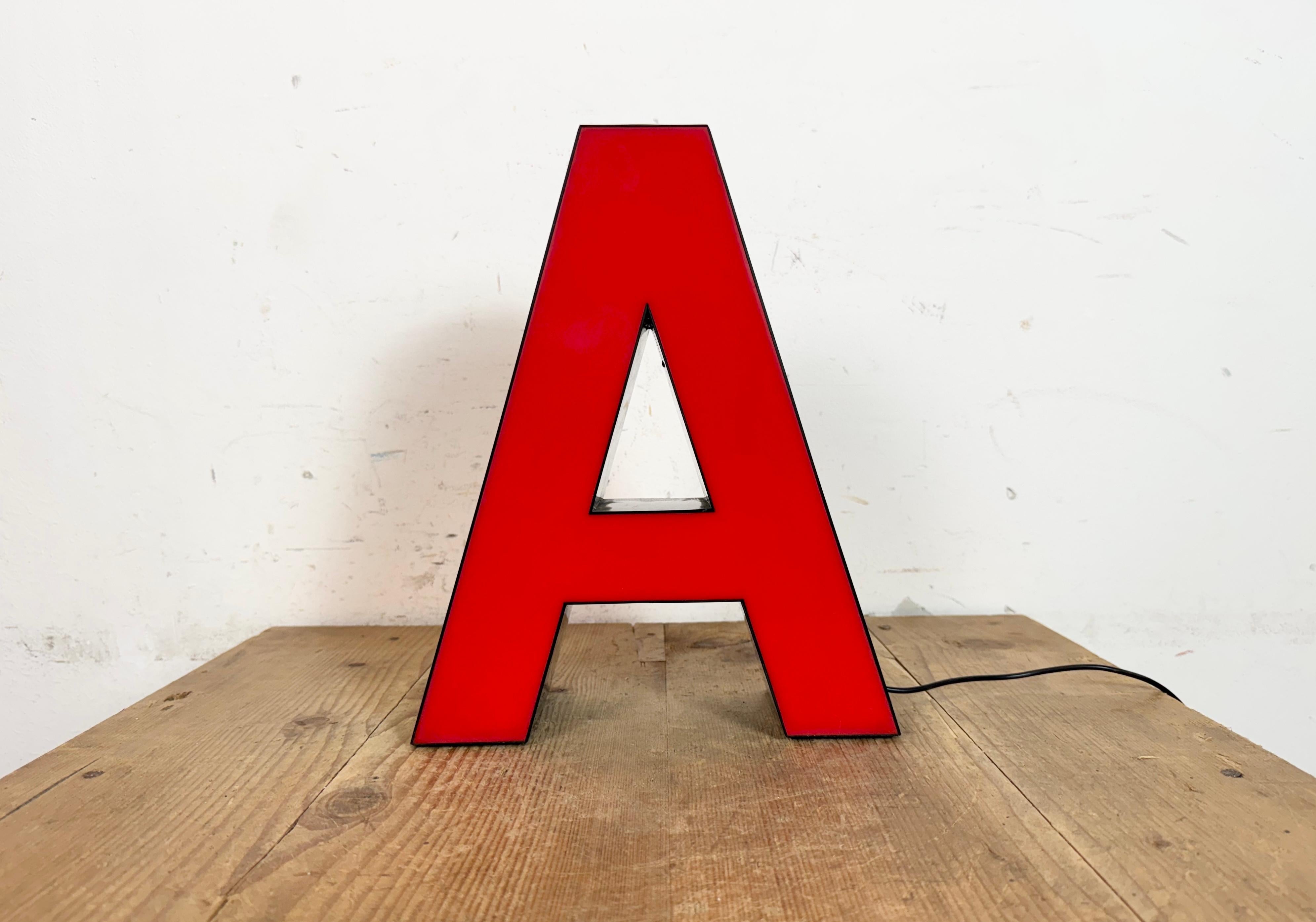 Dieser Vintage-Industrieleuchtbuchstabe A wurde in den 1970er Jahren in Italien hergestellt und stammt von einem alten Werbebanner aus einem alten Teppichgeschäft in Turin. Es hat einen schwarzen Eisenrahmen mit roter Kunststoffschrift. Sie ist mit