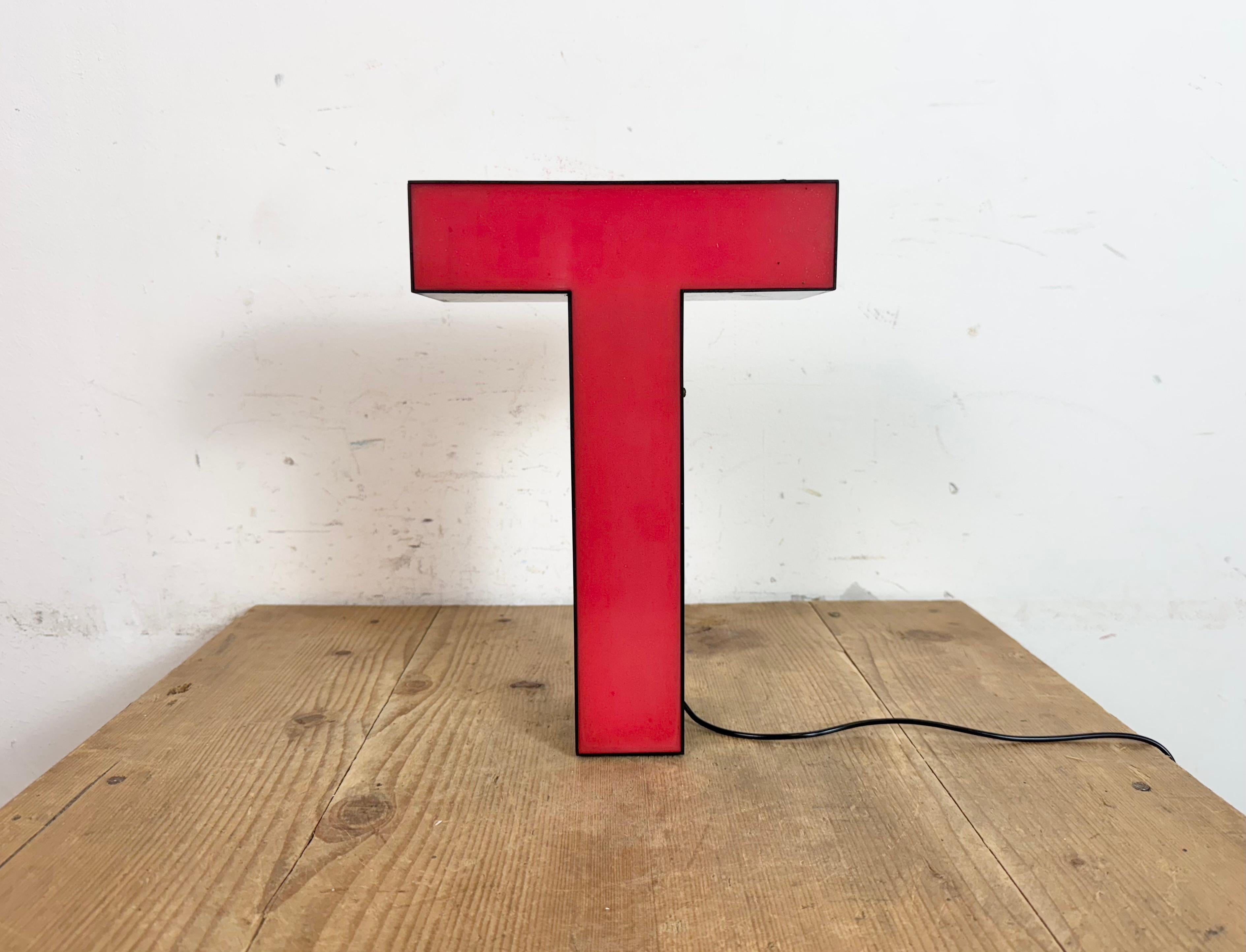 Dieser Vintage-Industrieleuchtbuchstabe T wurde in den 1970er Jahren in Italien hergestellt und stammt von einem alten Werbebanner aus einem alten Teppichgeschäft in Turin. Es hat einen schwarzen Eisenrahmen mit roter Kunststoffschrift. Der Brief