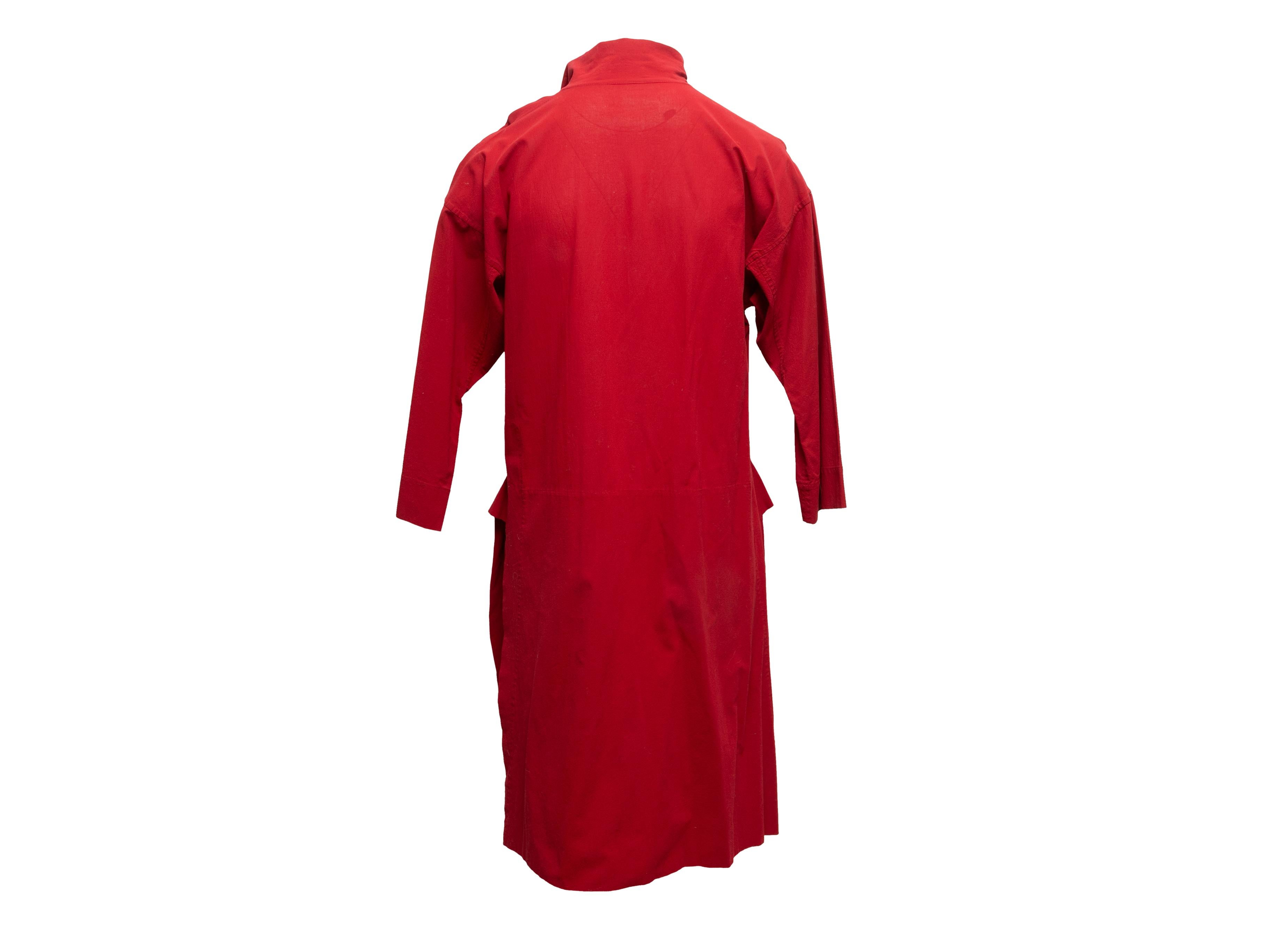 Vintage red knee-length tunic dress by Issey Miyake. Pointed collar. Slits at sides. Single pocket. Front button closures. 40