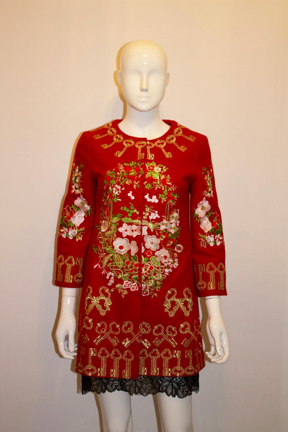 A stunning red jacket with wonderful gold embroidery . The jacket has a round neckline with popper fastening at the front and a pocket on either side.  The embroidery has a key and floral design.  The jacket is fully lined. 
Measurements : Bust