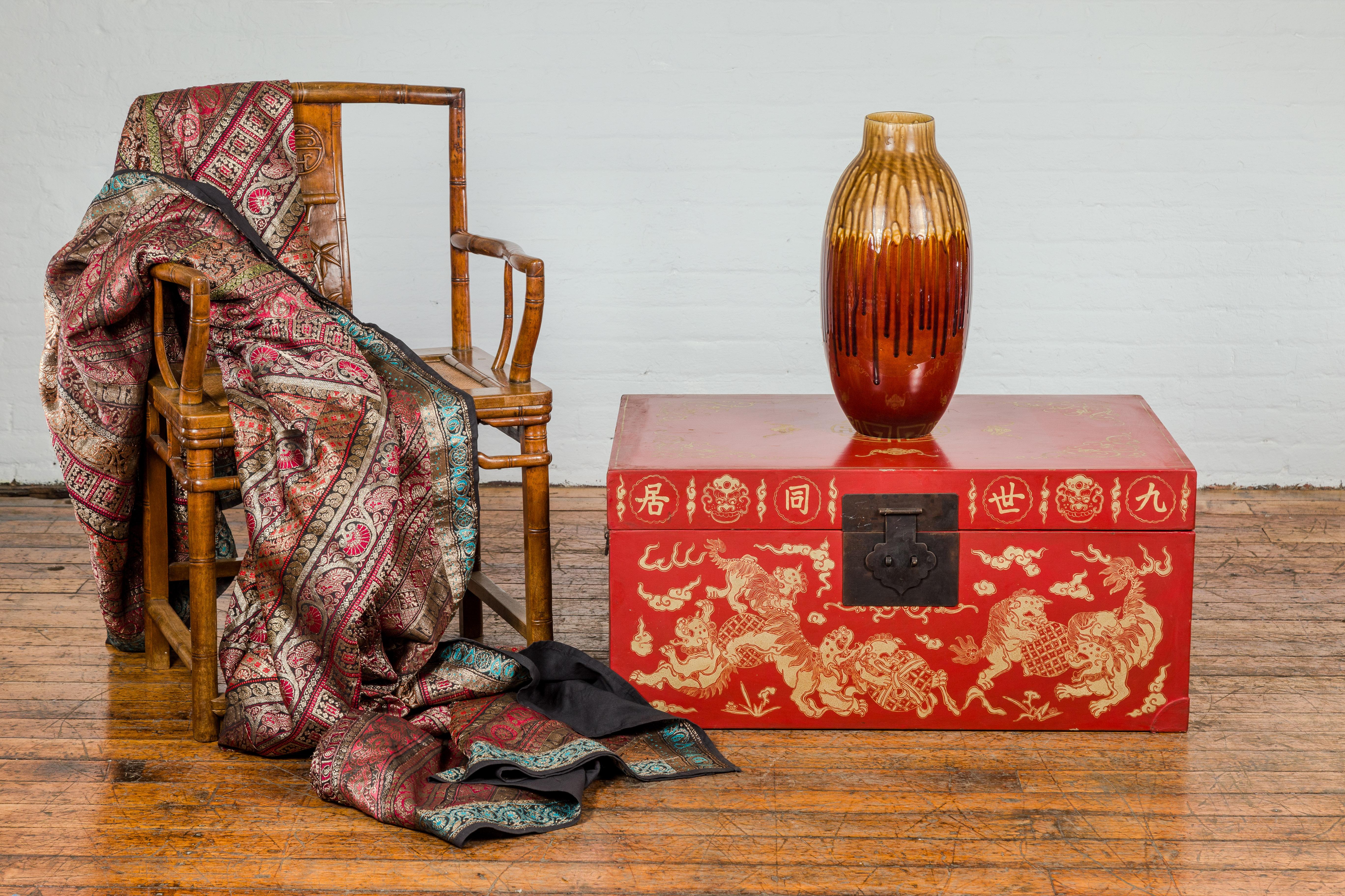 Chinesische Rotlacktruhe im Vintage-Look mit vergoldeten Fledermaus-, Wächterlöwen- und Wolkenmotiven. Diese chinesische Rotlacktruhe im Vintage-Stil ist ein beeindruckendes Beispiel für traditionelle Handwerkskunst in Verbindung mit symbolischer