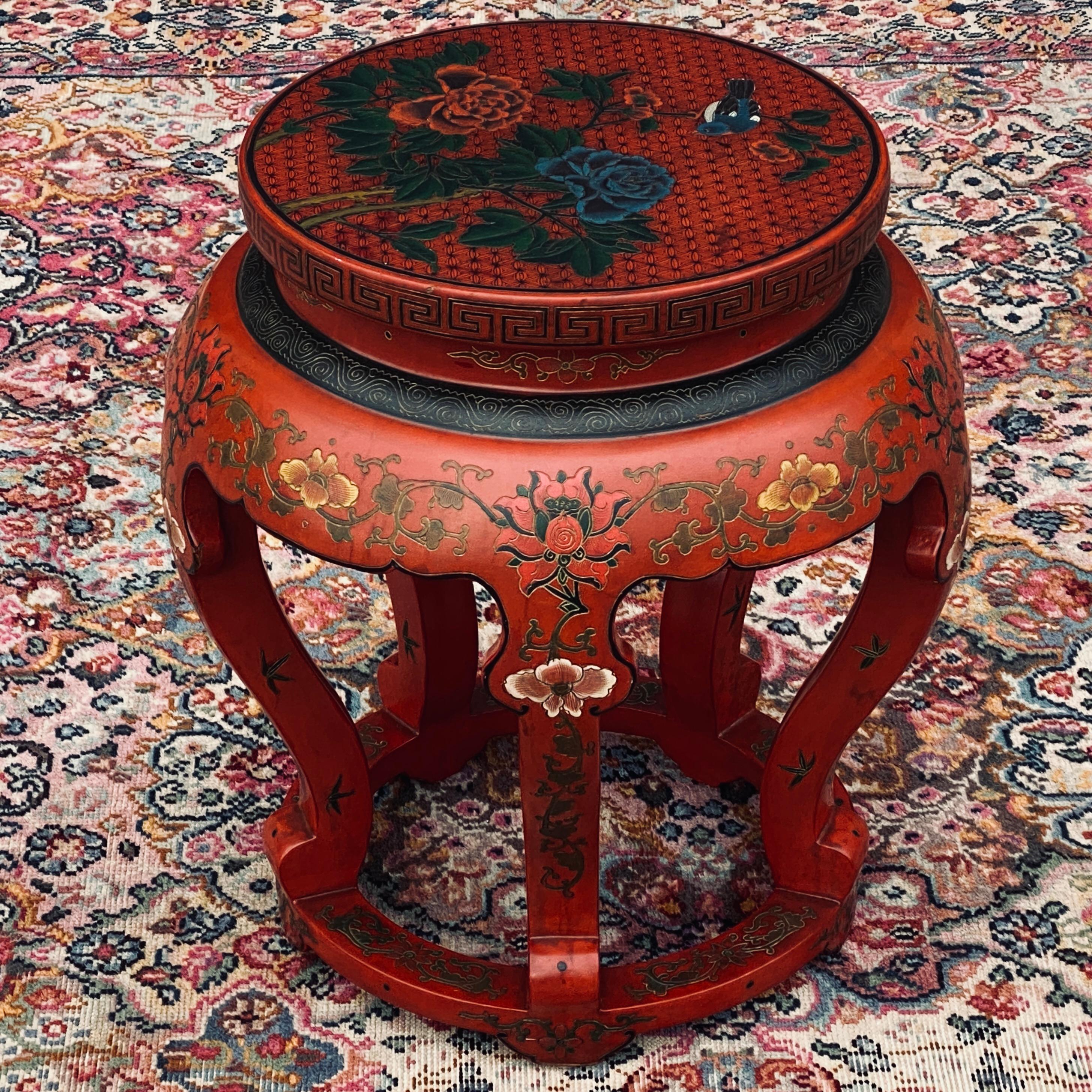Deep red lacquer Chinese stool or side table decorated with chrysanthemums, scrolling flowers, and a greek key pattern. Five ruyi-style legs with further hand painted flowers on each. Great accent piece that will enhance any room either as a side