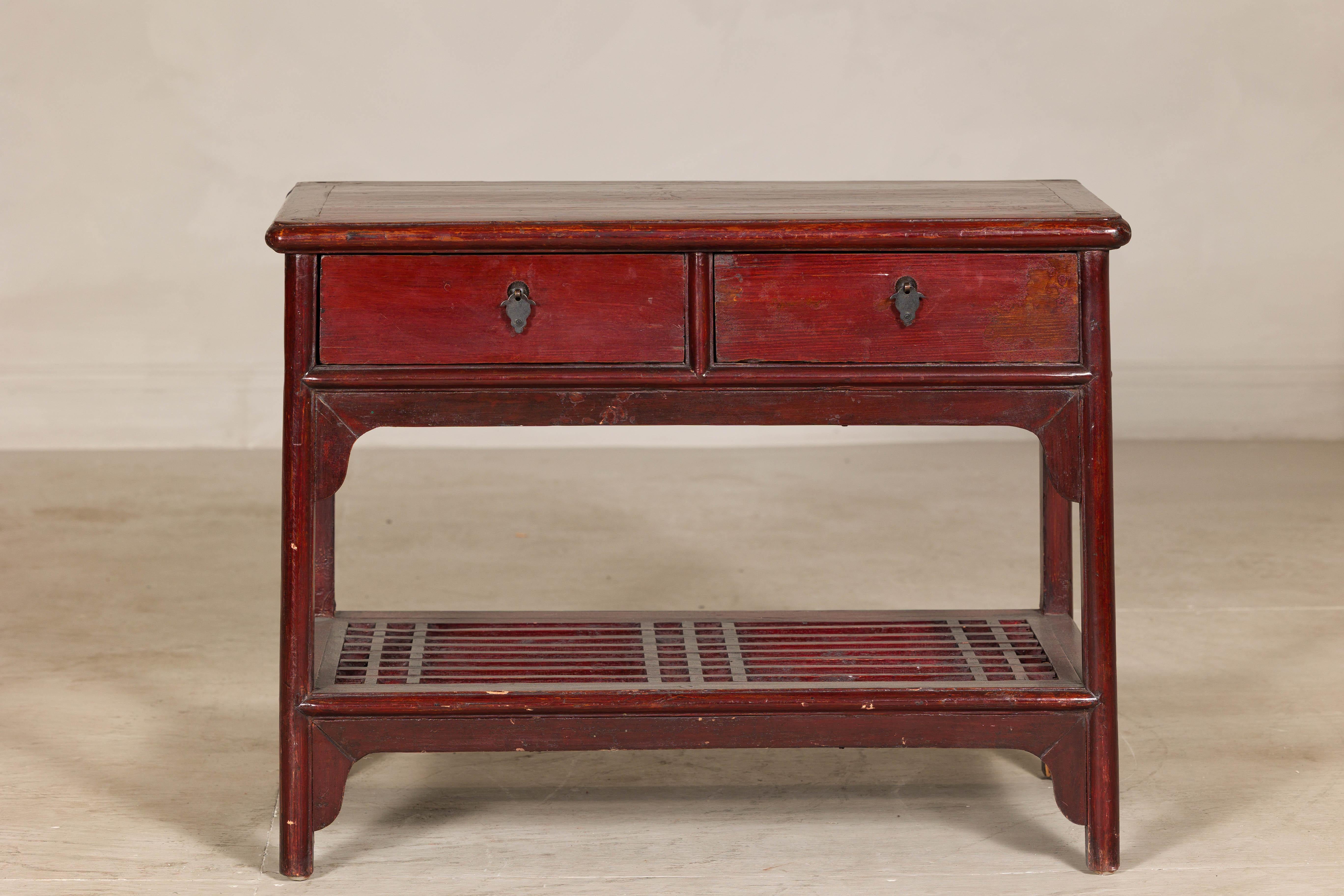 Crafted from solid elm or walnut, this vintage Chinese low side table features a deep reddish-brown lacquer finish that highlights the wood’s natural grain and enhances its warm patina. The design is both elegant and practical, with two drawers