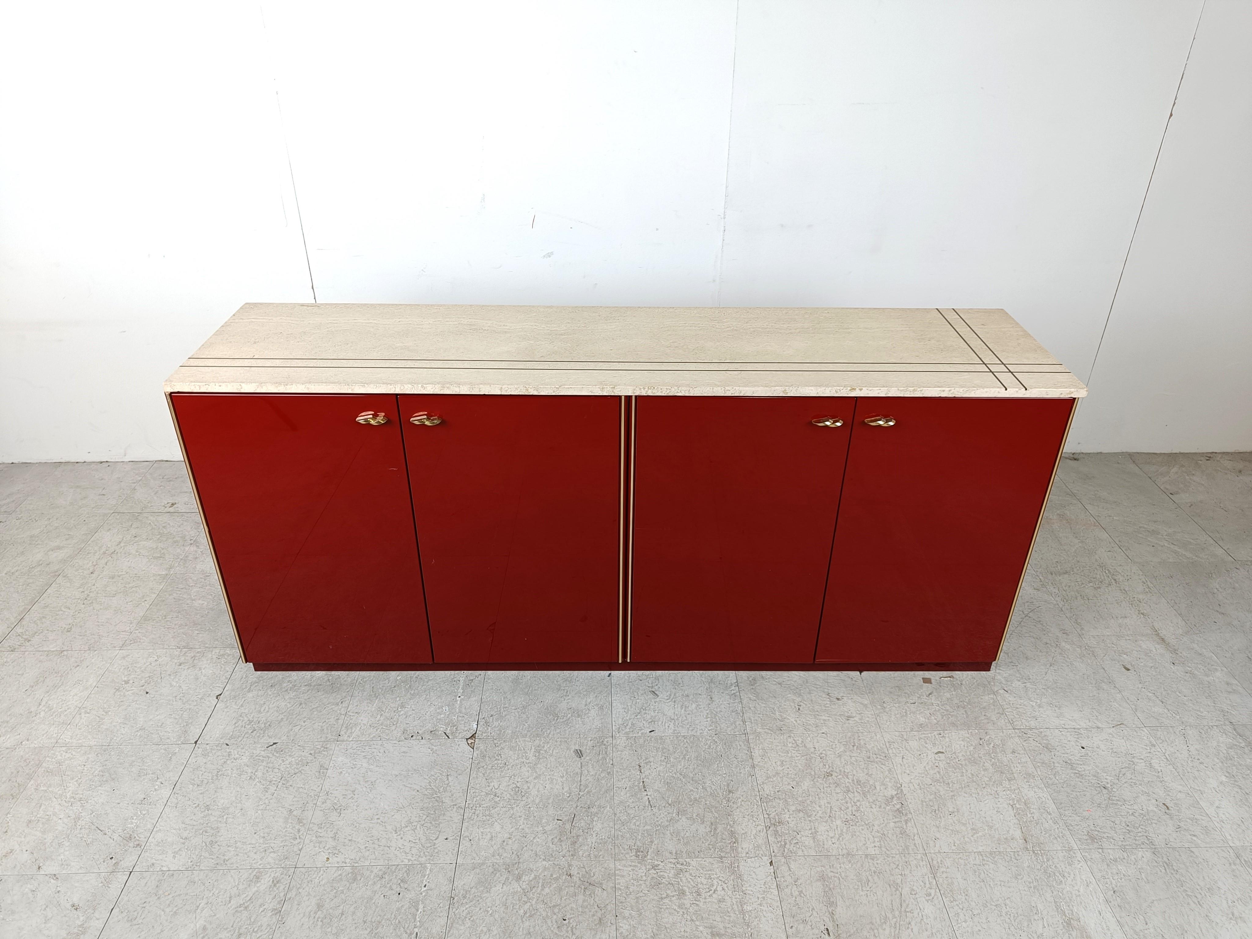 High gloss lacquered sideboard with brass handles and brass framing with a travertine table top.

Nicely inlaid brass into the travertine top.

Beautiful and luxurious piece.

Some nice patina on the handles, good overall condition

1980s -