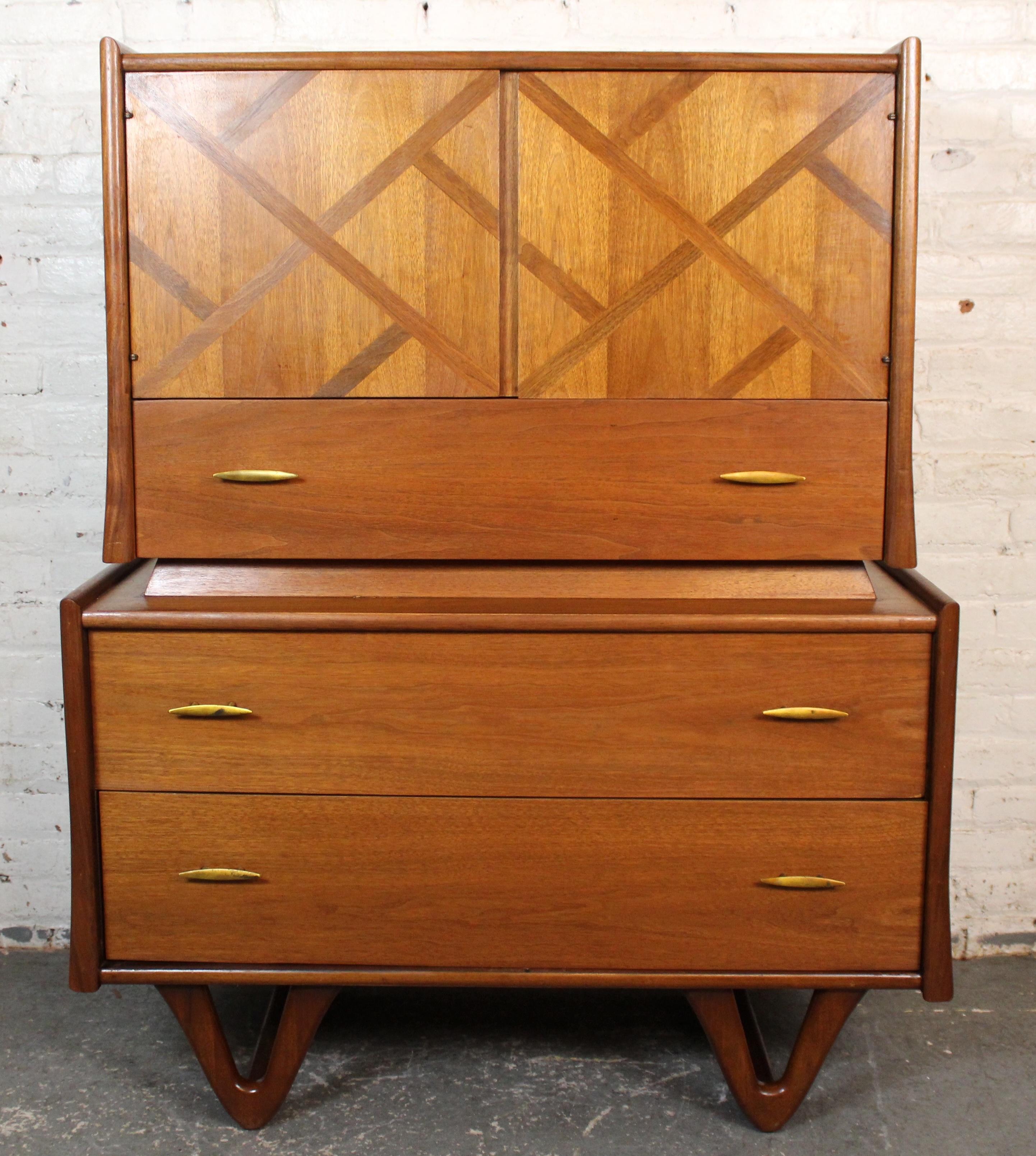 Classic and well-crafted, this vintage highboy dresser was produced by the talented union builders of Pennsylvania's Red Lion Furniture. Boasting rich walnut construction with clean lines, exquisite inlaid detailing and uniquely carved sled legs as