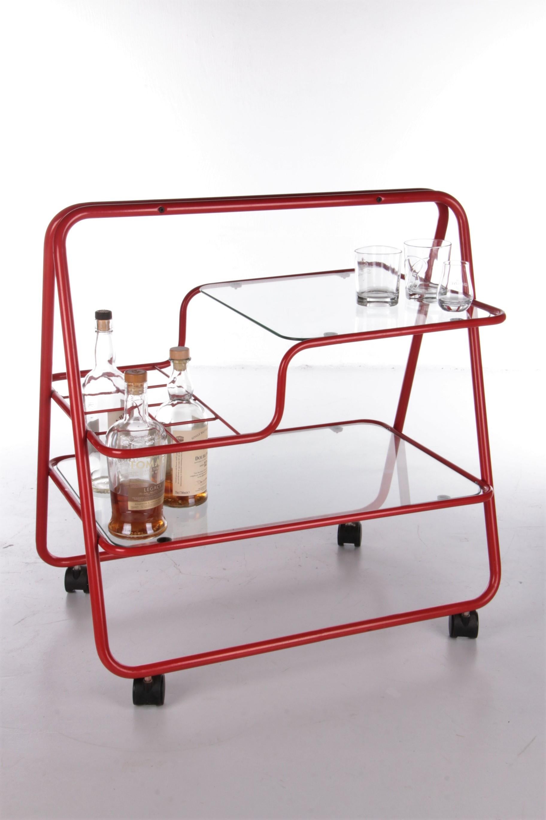 Intage red metal unique trolley or bar cart, 1970s

This is a beautiful trolley from the 1970s.

The bottom leaf is made of glass and the top leaf is also glass, the frame is made of beautiful red and metal. On the second floor there is also a