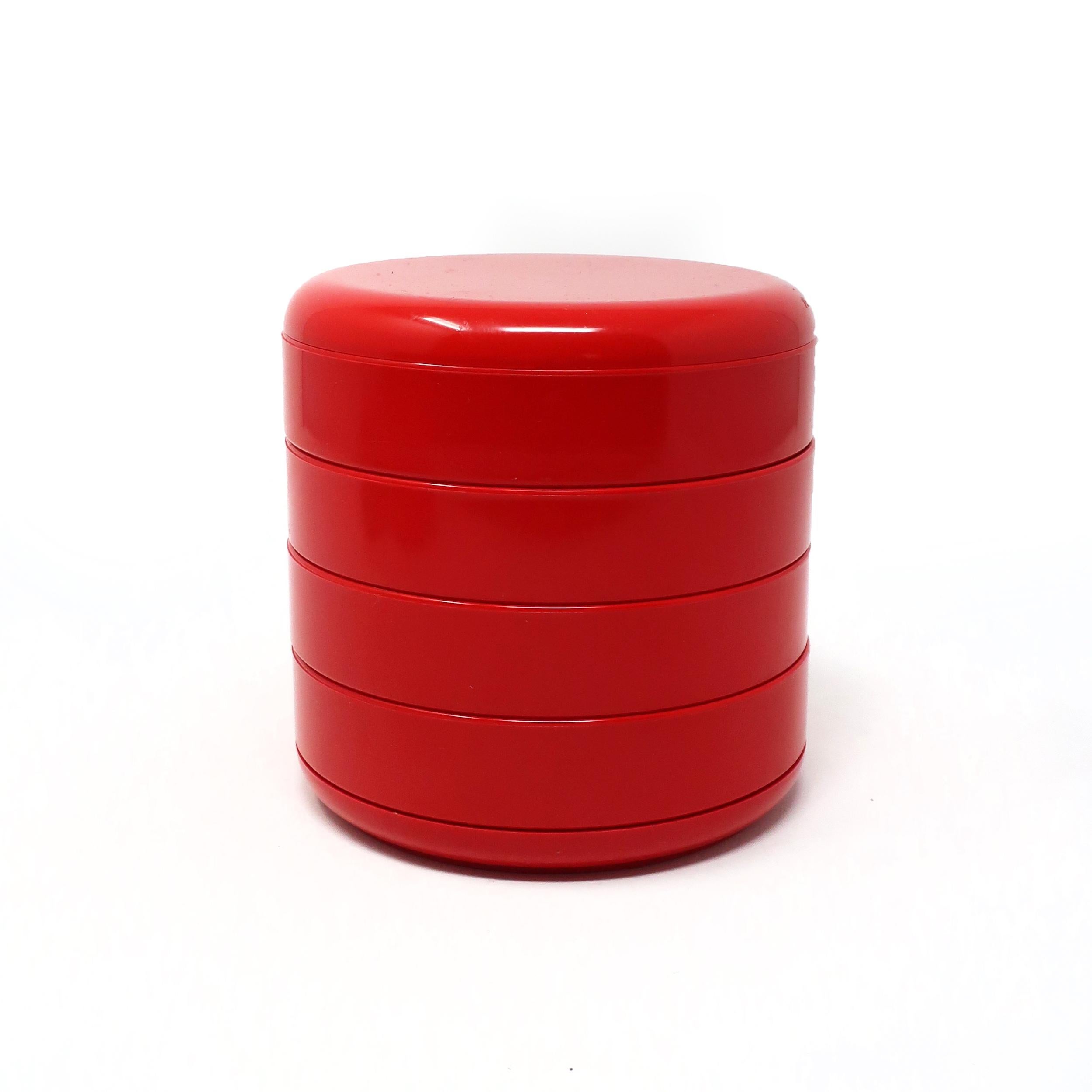 An ingeniously designed and iconic multi-drawer rotating organizer in red plastic that is great on a dresser or desktop for office supplies, sewing needles and threads, makeup, or jewelry. With a lid hiding the contents, the four plastic storage