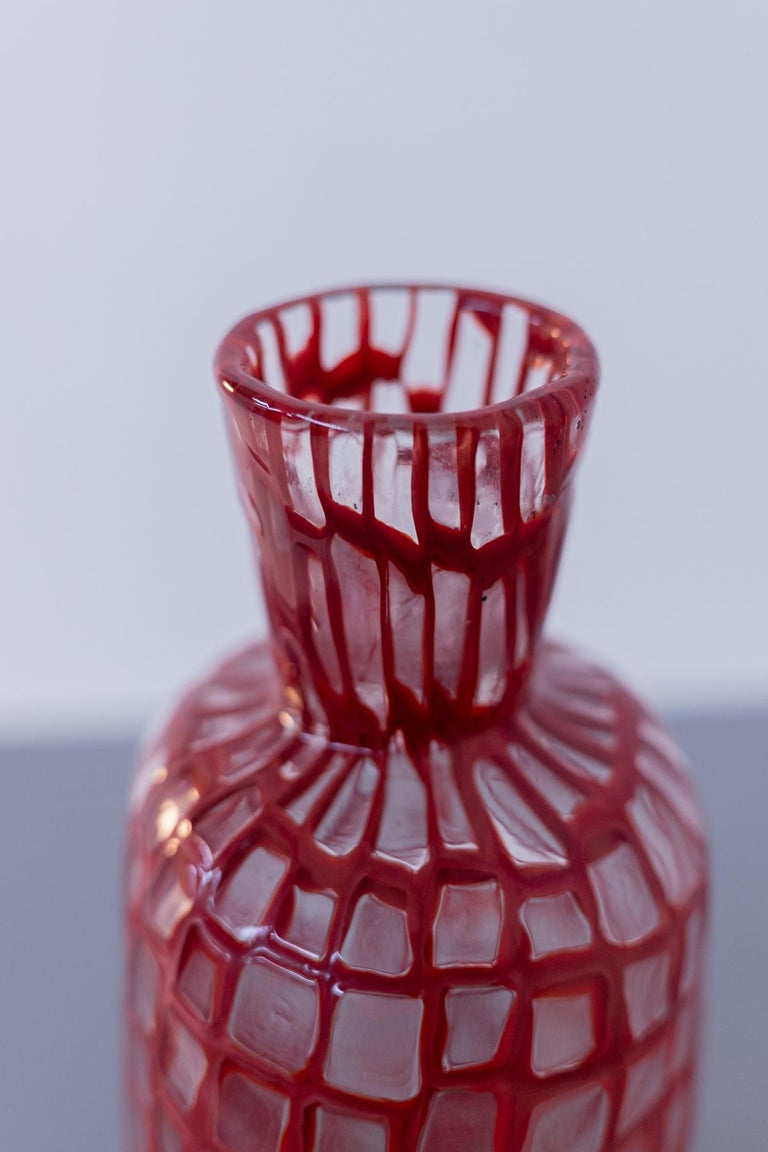A particular vintage vase in Murano glass by Tobia Scarpa for Venini, designed in 1960. The vase was made with the techniques of blown glass and Murrina. The vase by Tobia Scarpa has a coral red colour that predominates over the transparent colour