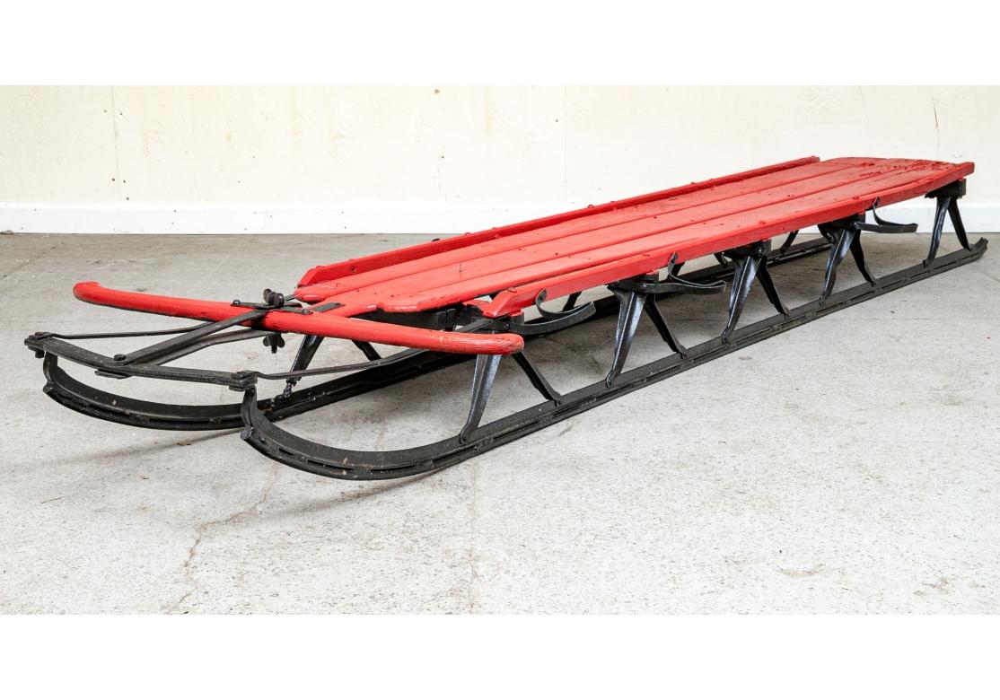 An extra long red paint decorated wood sled with black painted rails with seating for four. No visible marks. Attributed to Fexible Flyer, circa 1930's probably by S.L. Allen Co. of Philadelphia.

Dimensions: 29