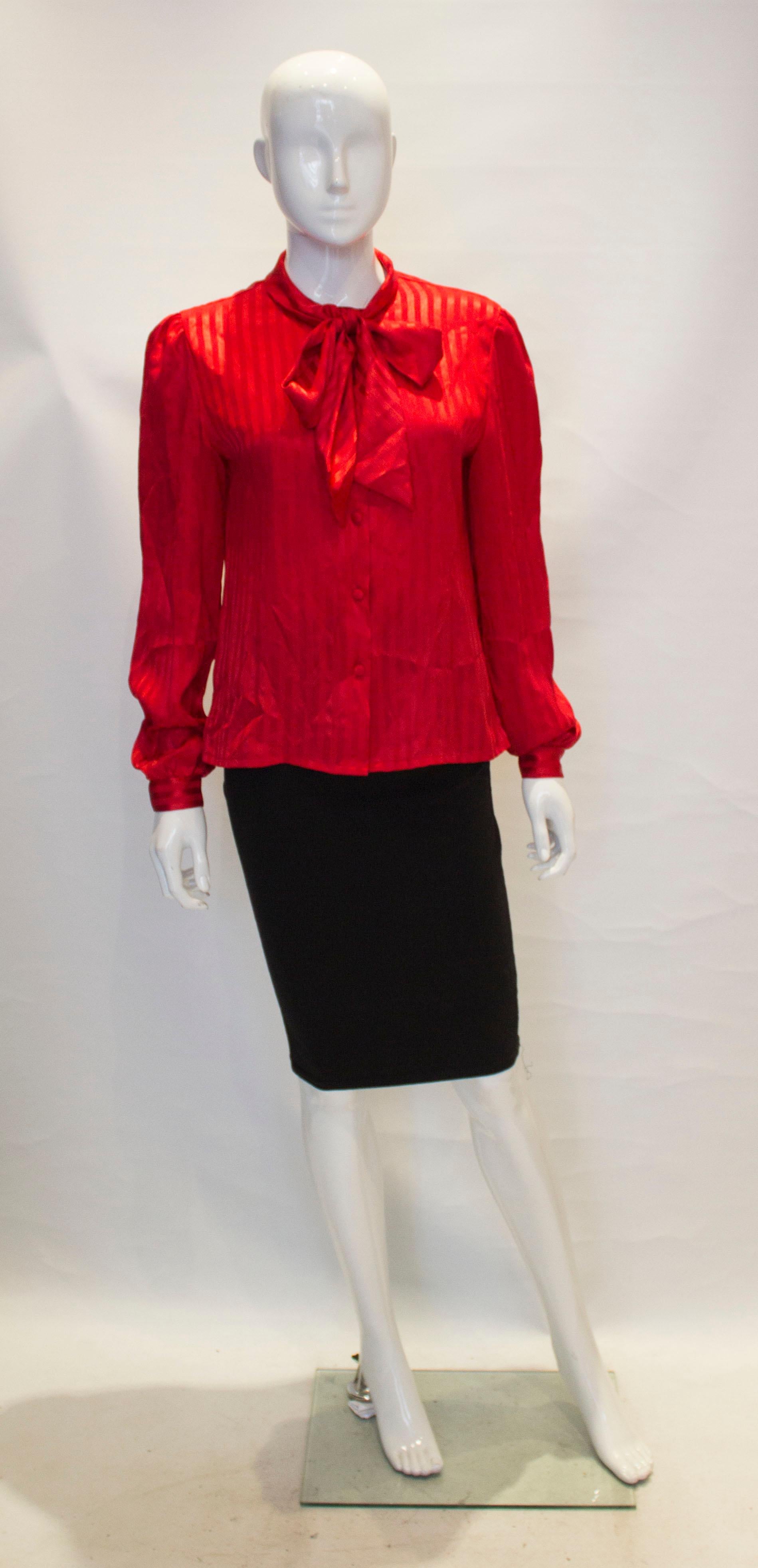 A chic vintage red pussybow blouse by Mr Pearcy.  The blouse has a  fabric covered button opening.