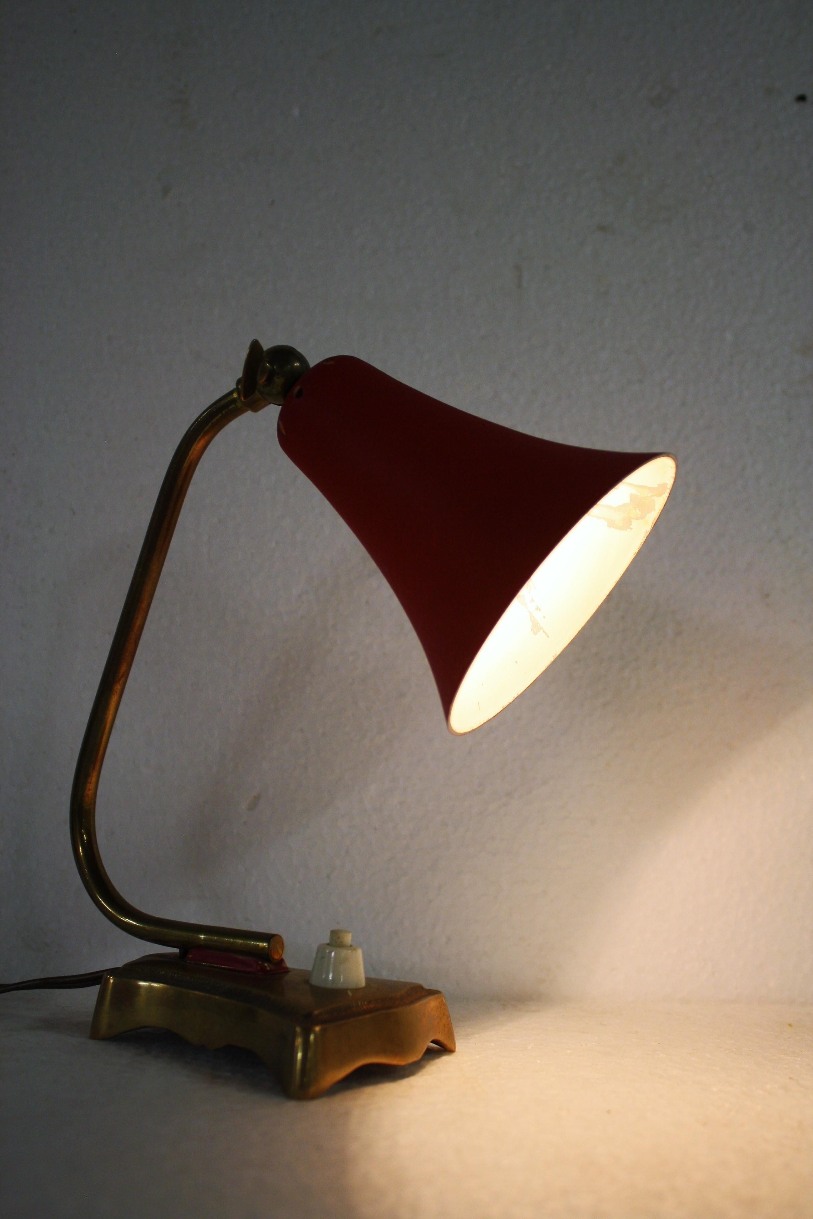 Small articulated desk lamp with a red aluminum shade mounted on a decorated brass base.

Good original condition, slight loss of enamel inside the shade.

The lamp takes a small e14 light bulb.

Tested and ready to use.

1950s,