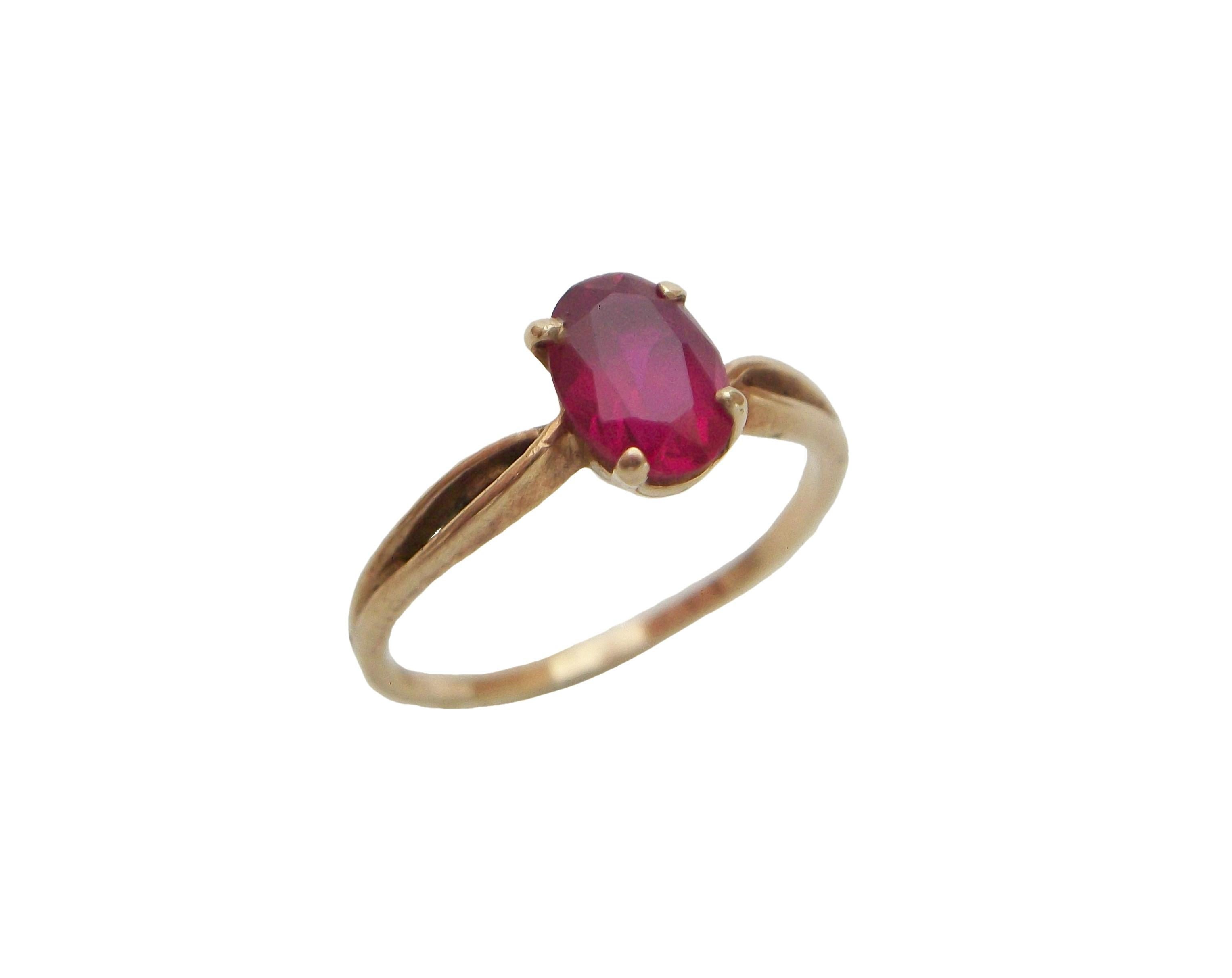 Vintage red topaz and 10K yellow gold ring - classic style - the topaz gemstone claw set (approximately 1 carat weight - oval faceted cut - 7 x 5 x 4 mm.) -10K to the interior of the band (as photographed) - signed (BTA? - worn mark -