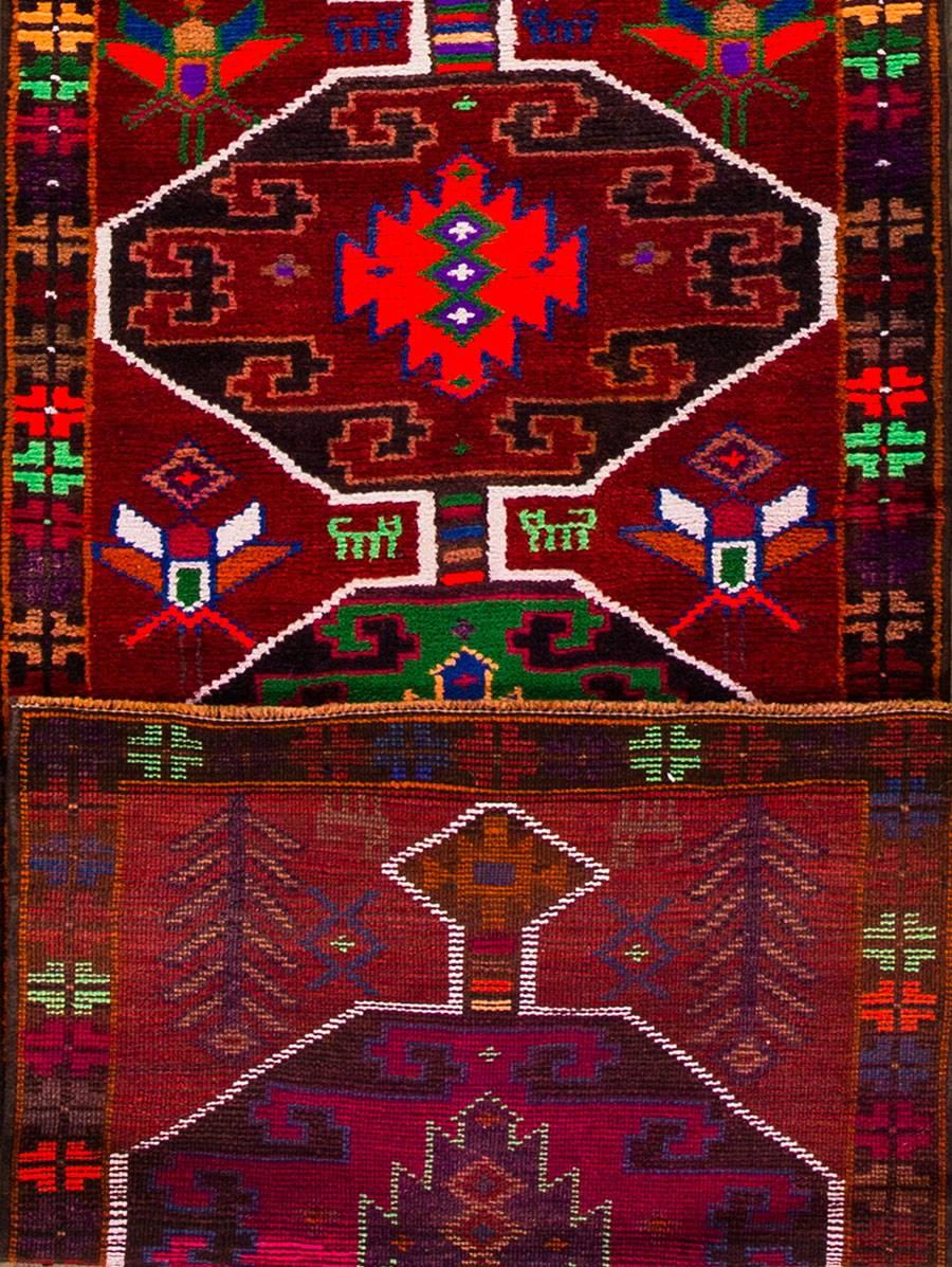 Vintage 1970s Turkish Anatolian runner rug. This piece has a multicolored geometric border, red field, and a multicolored tribal design. Measures: 2.05x10.08.
