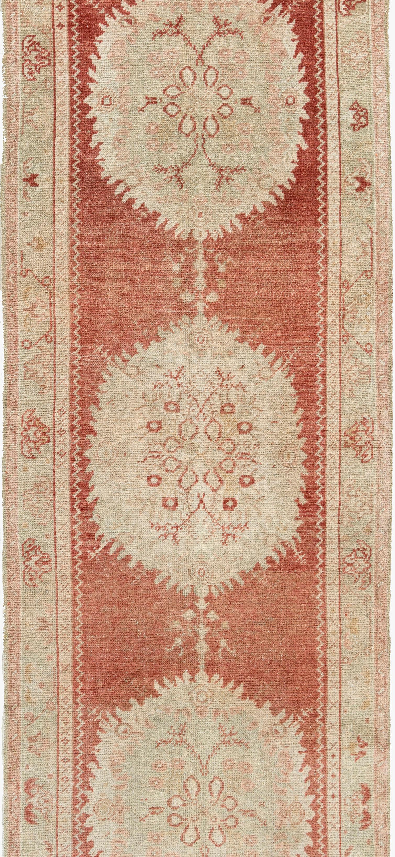 2'11 x 11'7. Questo delizioso tappeto annodato a mano in Turchia negli anni '40 presenta un'abrasione naturale (cambiamento di colore) comune nei pezzi antichi e che conferisce un'unicità al tappeto. Tutti gli elementi che si cercano in un tappeto