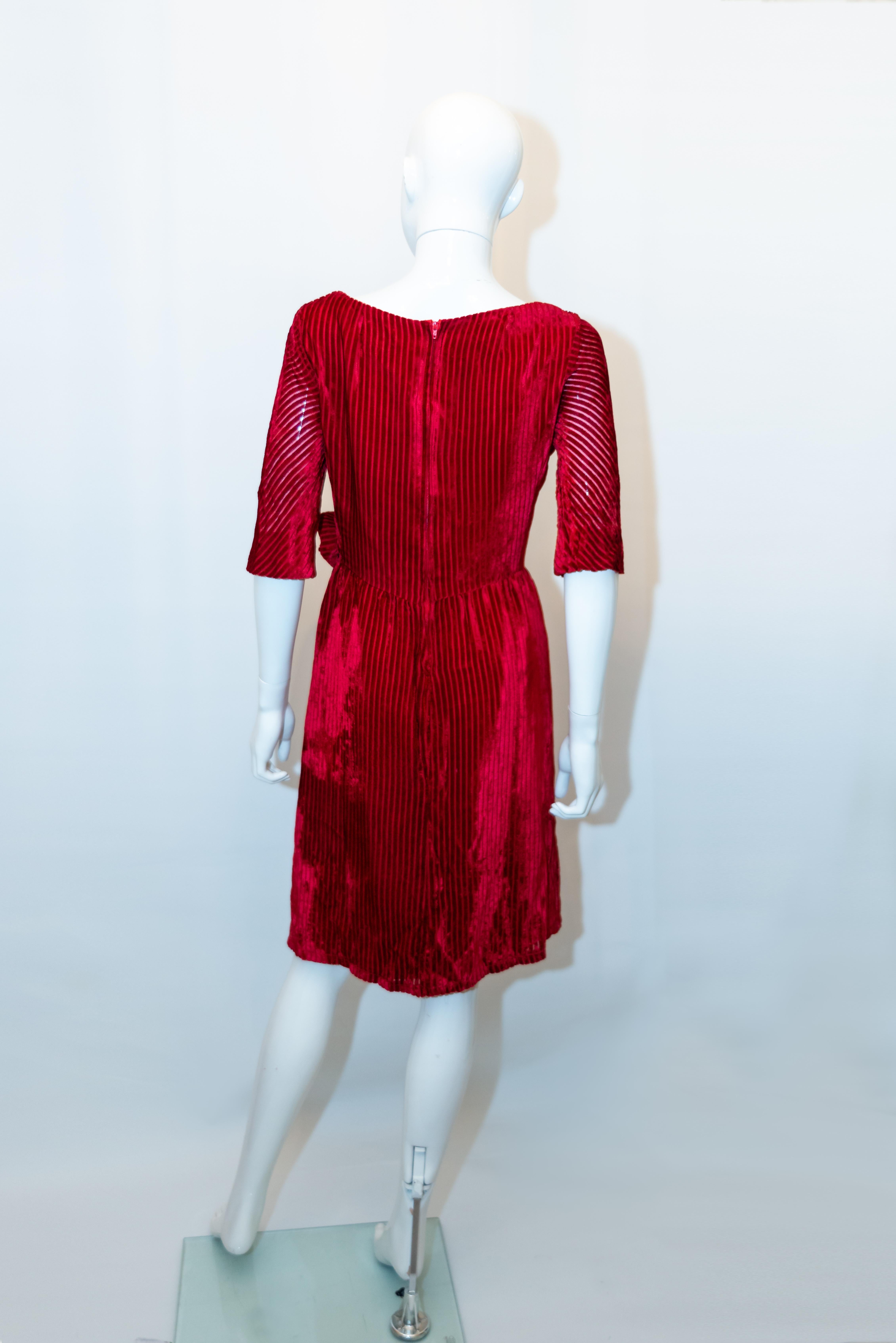 A chic red velvet vintage dress by Frank Usher.  The dress has a wrap over front and central back zip. Measurements; Size 38, Bust 36'' ,length 38''
