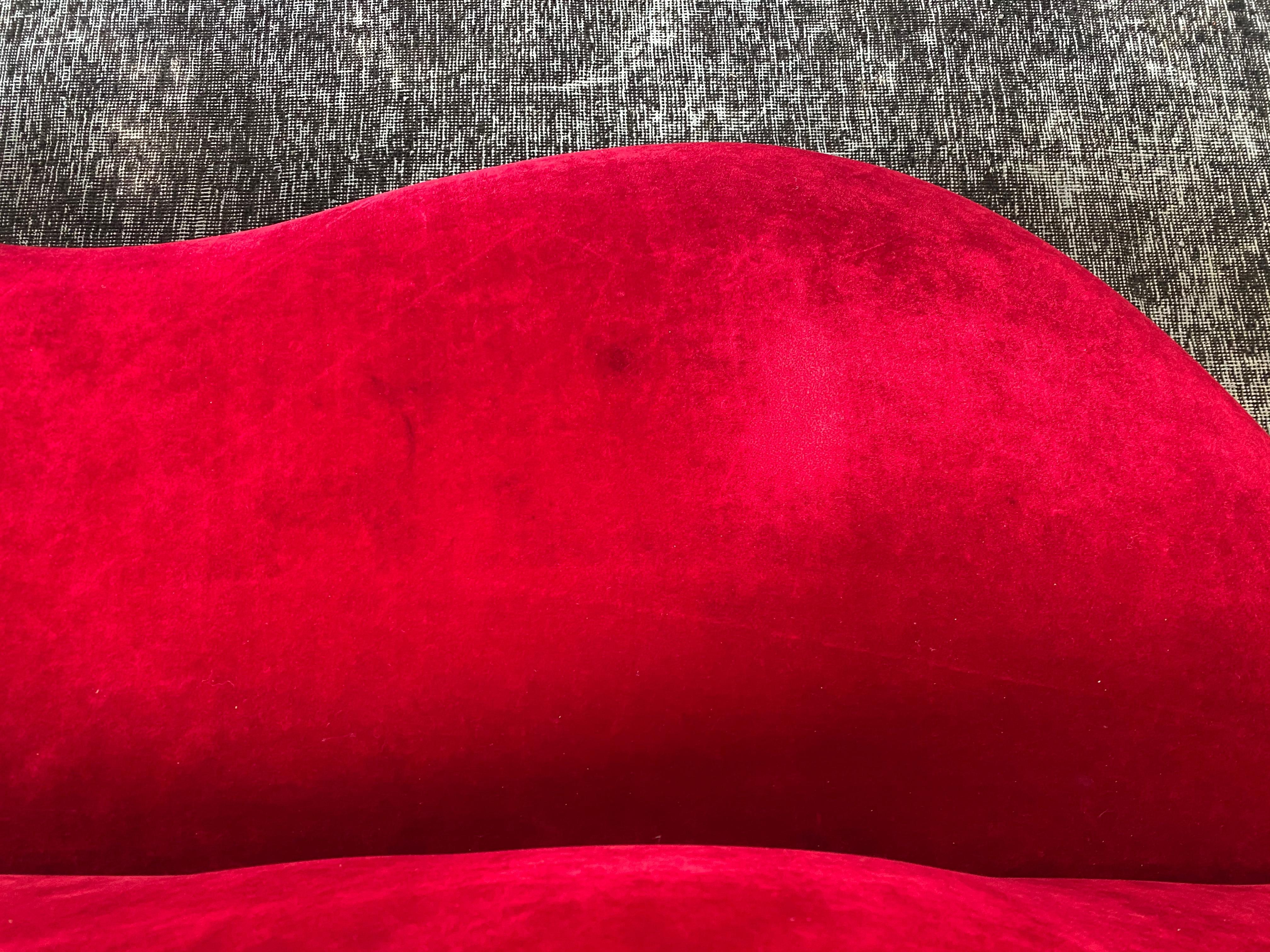 A soft and small vintage red velvet lips sofa is in overall good condition. In the manner of Dali, Gufare Bocca. Velvet upholstery with several visible flaws as seen in photos.
circa 1970s.
Dimensions:
23