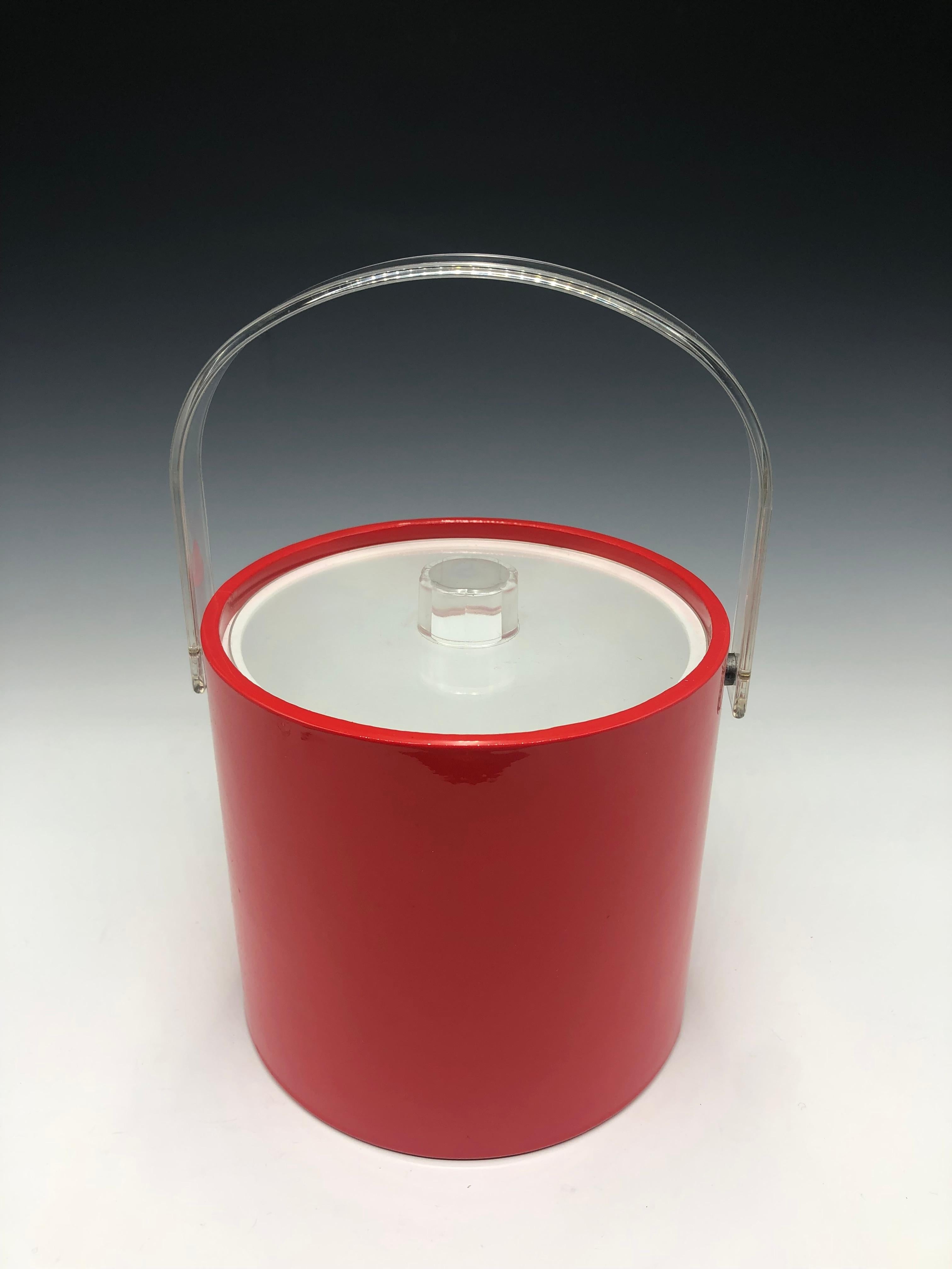 Shiny red mid-century modern vinyl-covered ice bucket with white interior by Mr Ice Bucket. 

This 3-quart double-walled ice bucket features a glossy red exterior paired with a clear Lucite lid and handle. Its bright color and clear accents make it
