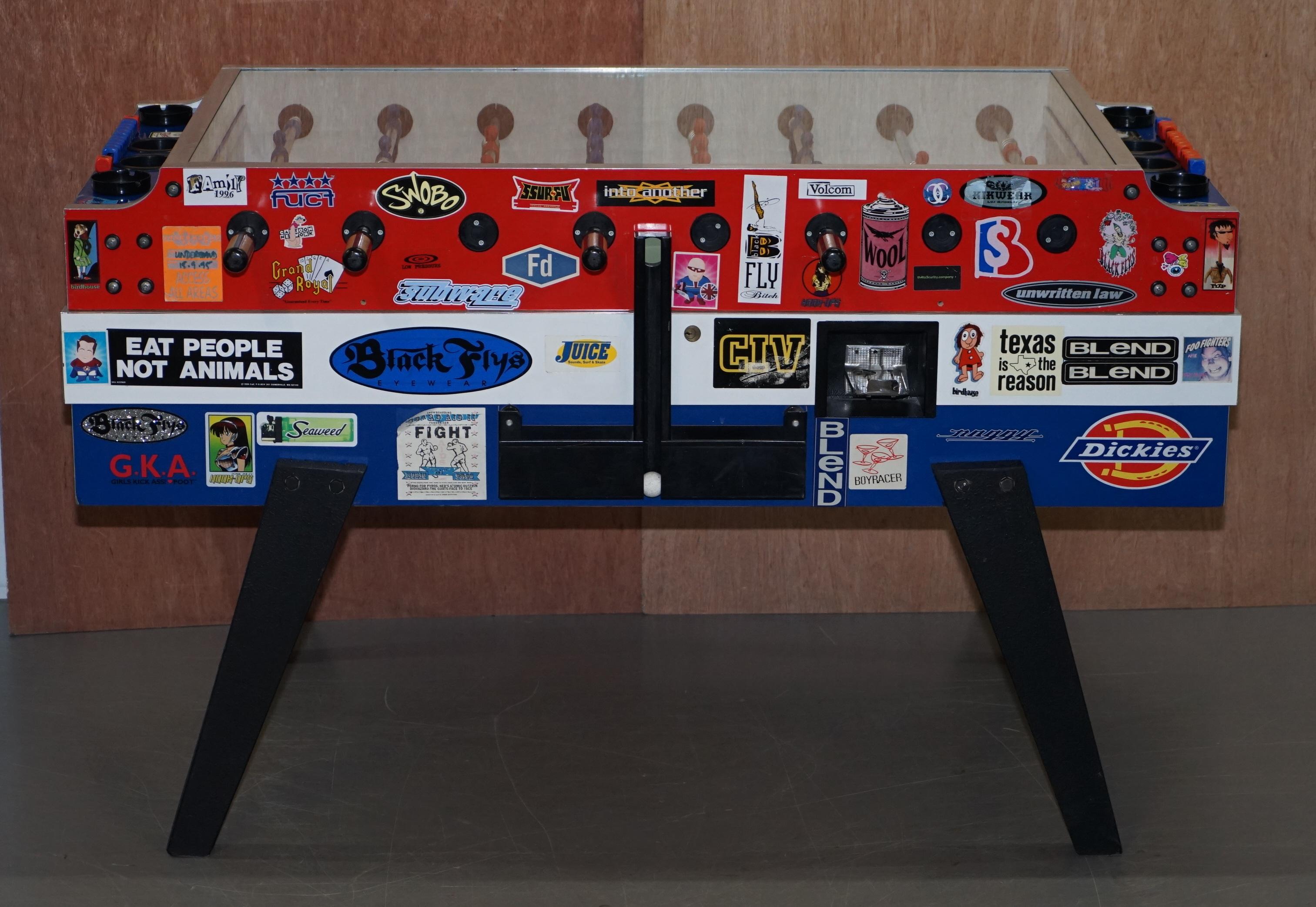 We are delighted to offer this lovely vintage foosball table covered in pop culture stickers

A very good looking well made and decorative piece, it has been perfectly decorated with pop culture, political and comical stickers, this is ready to go
