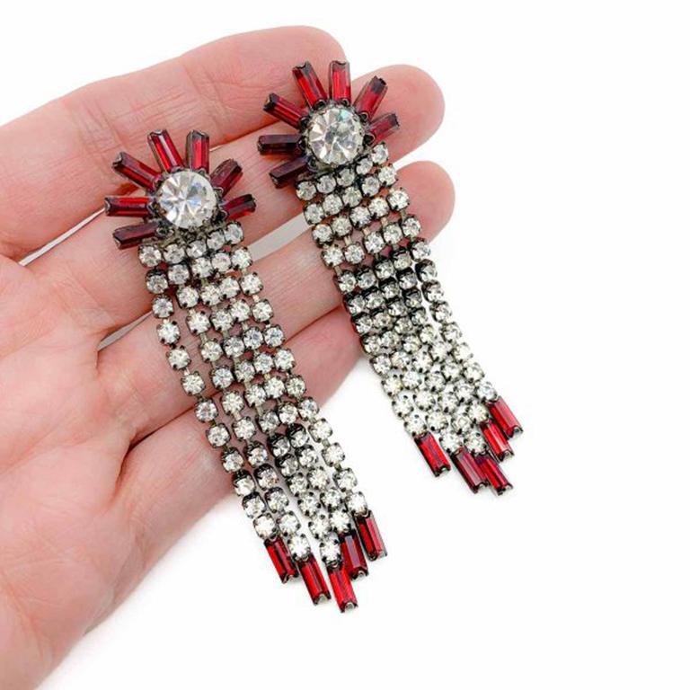 Vintage Red Crystal Cascade Earrings. Featuring deep red baguette cut crystals claw set in a fan shape that sits on the ear and gives way to a shimmering and glamorous cascade of crystal rhinestones. Set in gunmetal tone metal. Very good condition.