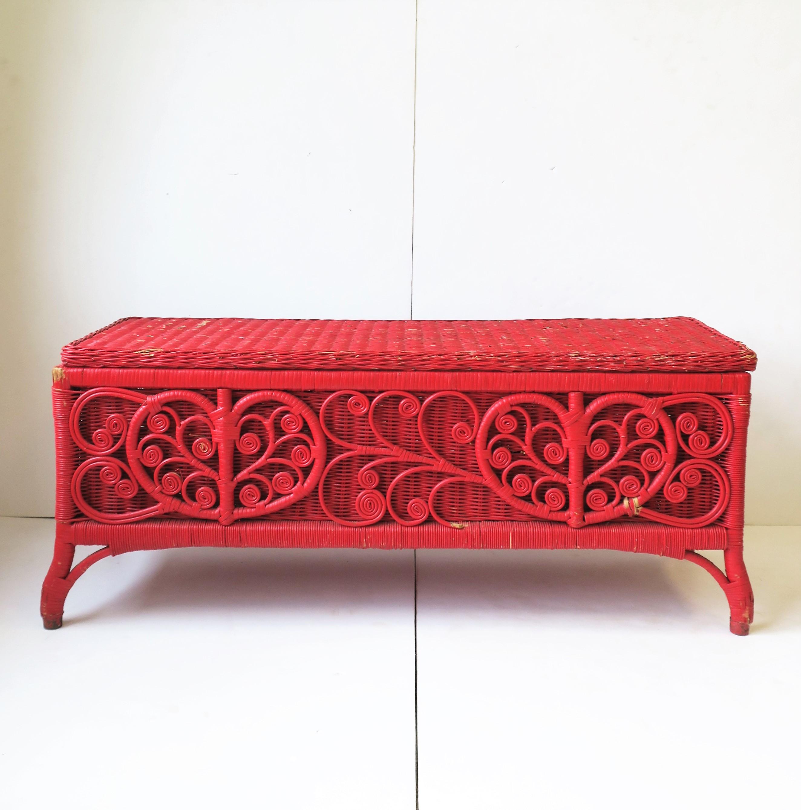 A vintage red painted wicker rattan bench with storage, circa early 20th century, USA. Piece could also double as a coffee or cocktail table. Dimensions: 40.75