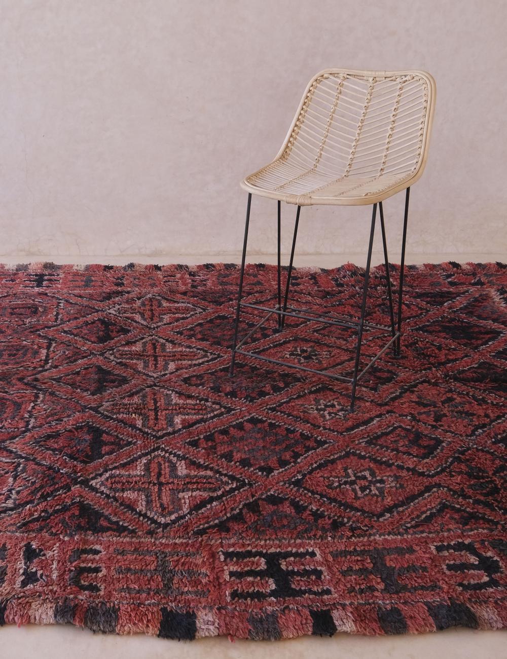 Una alfombra marroquí vintage increíblemente especial y coleccionable de la tribu Beni M'Guild. Esta rica alfombra multicolor presenta un complejo dibujo repetido de símbolos bereberes o amazigh comunes.  Esta pieza bohemia fue tejida a mano en