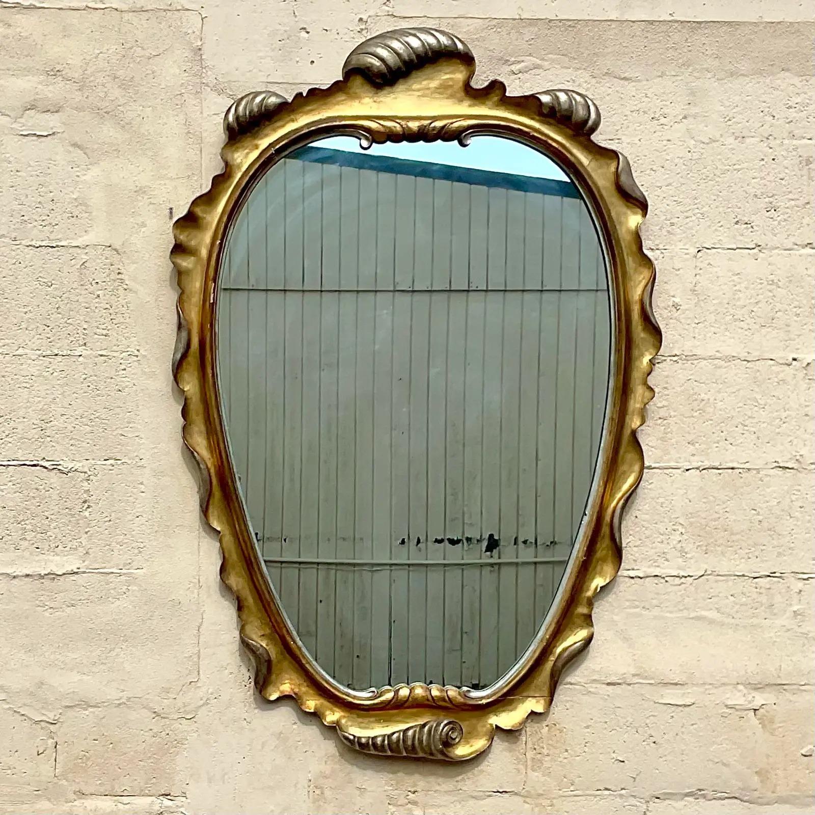 Vintage Regency gilt wall mirror. Made by the Fratelli Paoletti Firenze group in Italy. Beautiful wave design in the striking large frame mirror. Acquired from a Miami estate.