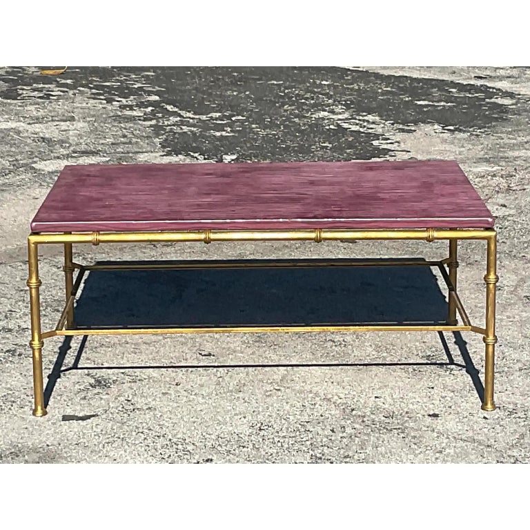 A stunning vintage Regency coffee table. Designed by Amanda Nisbet for Niermann Weeks. Unmarked. Beautiful gilt bamboo frame with a chic embossed faux leather top. Acquired from a Palm Beach estate.