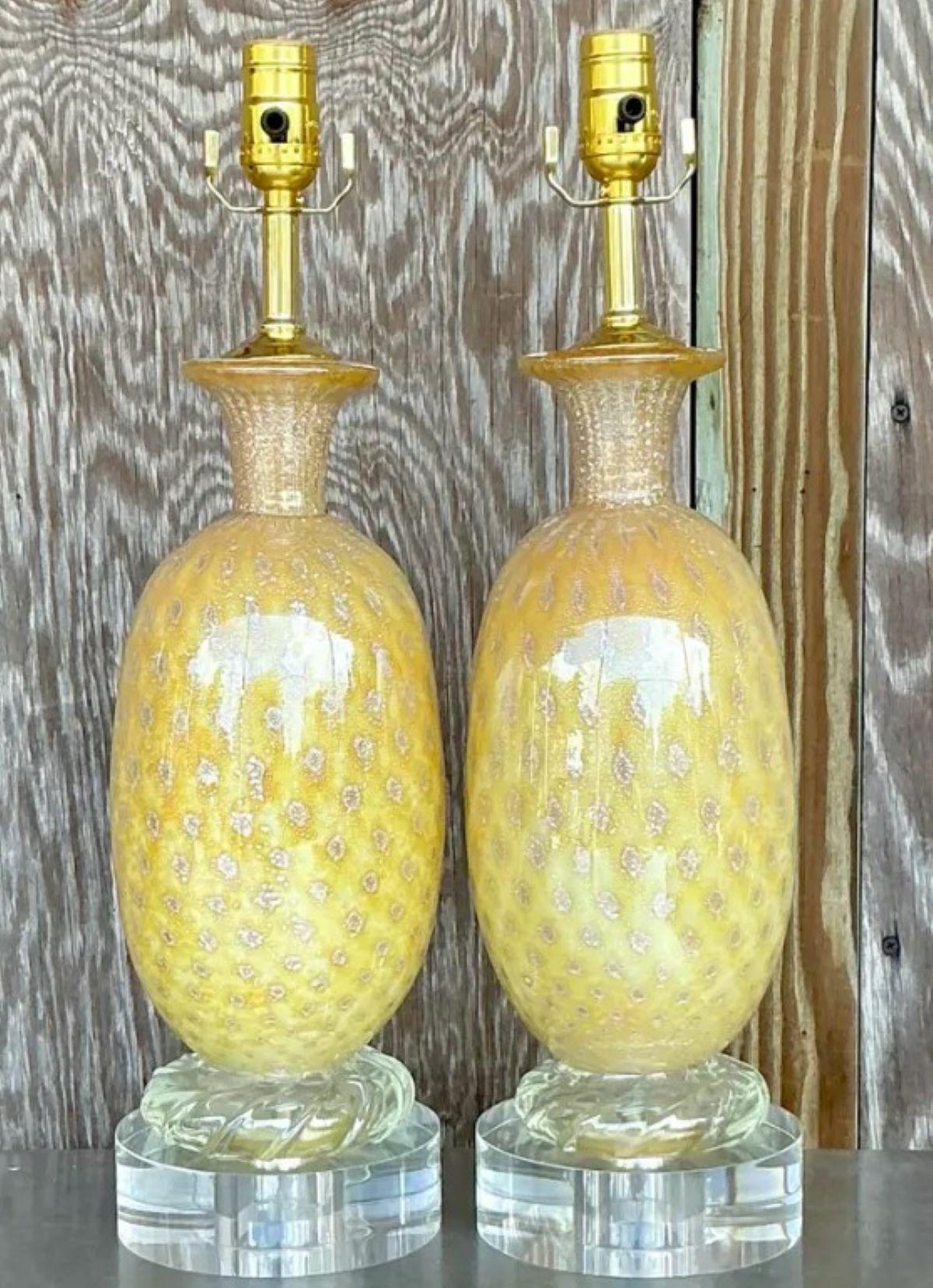 Infusez une élégance lumineuse dans vos intérieurs grâce à cette paire exquise de lampes en verre d'art Vintage Regency, inspirée par l'artisanat de Murano. Ces beautés soufflées à la main présentent une teinte dorée éclatante et une texture