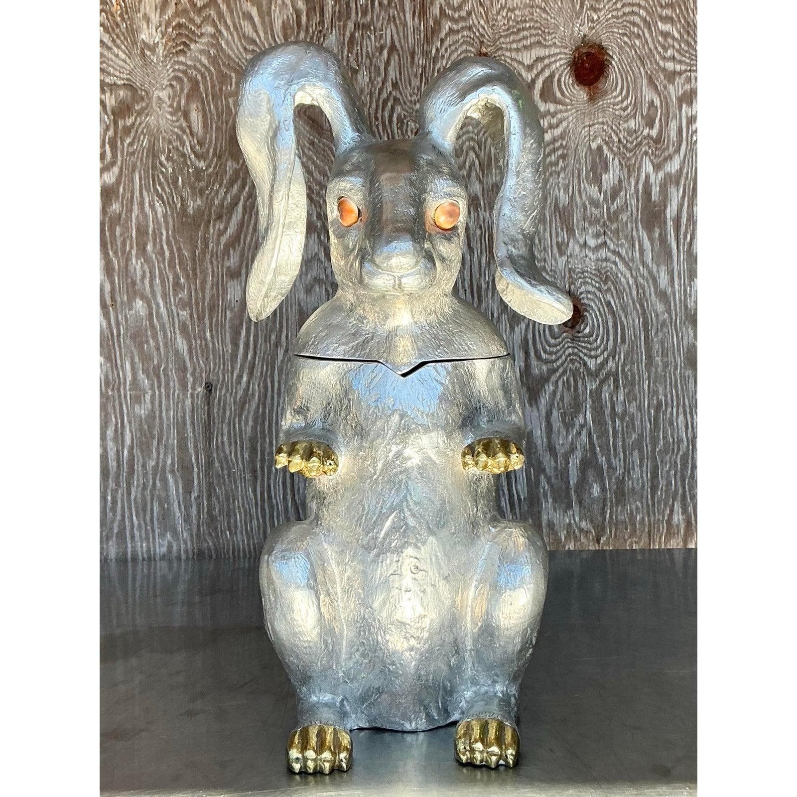 Aporta una caprichosa elegancia a tus recepciones con esta champanera vintage con forma de conejito de Arthur Court. Diseñada en el emblemático estilo Regencia, esta pieza única presenta un encantador motivo de conejito, con intrincados detalles y