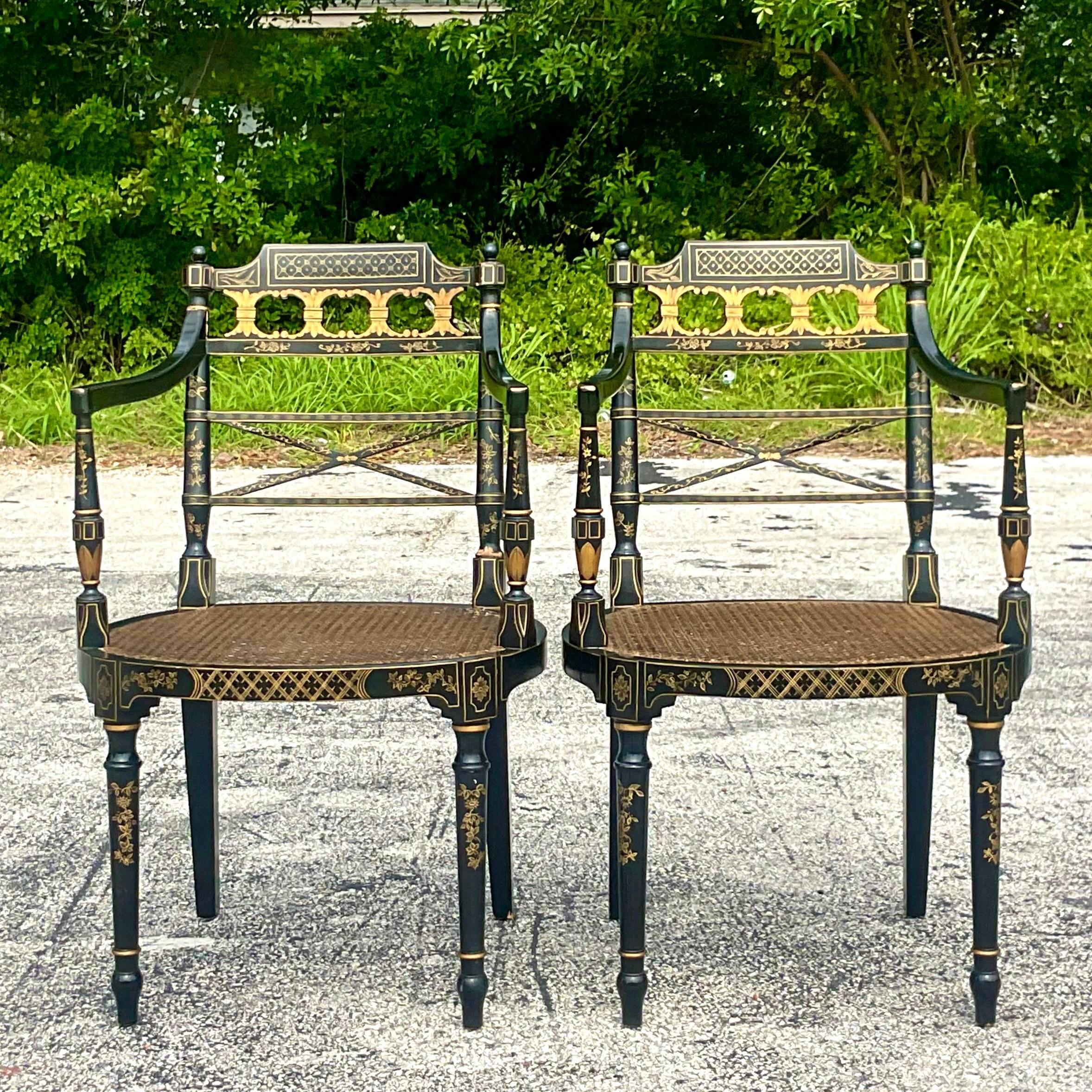 A fabulous pair of vintage Baker Directorie chairs. Made by the iconic Baker group. Part of their Charleston collection. Beautiful hand painted gilt detail with inset cane seats. Tagged on the bottom. Acquired from a Palm Beach estate.