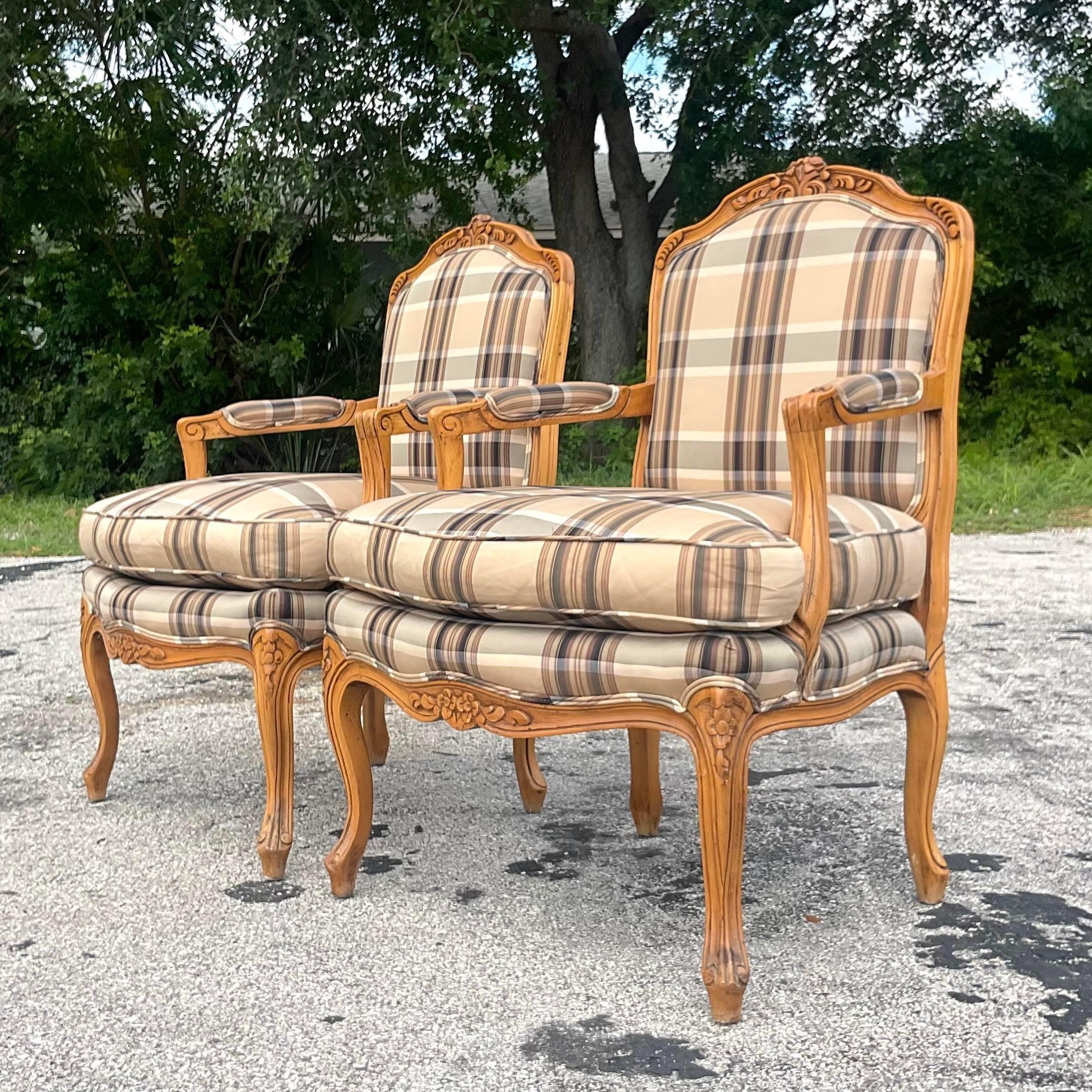A fabulous pair of vintage Regency Bergere chairs. Made by the iconic Baker group. Beautiful neutral plaid in black and tan. Acquired from a Palm Beach estate.