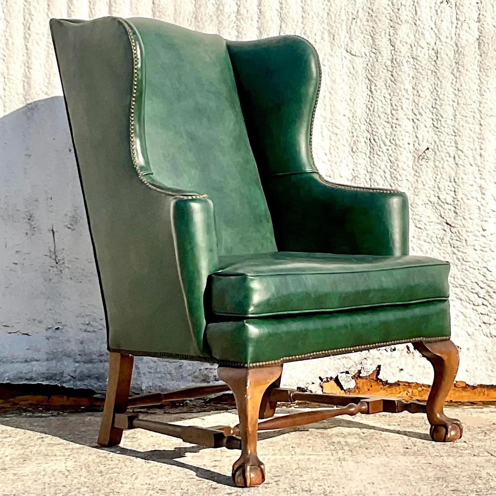 A fabulous vintage Regency wingback chairs. Made by the iconic Baker Furniture group. Chic deep green leather with nailhead trim. Imagine how beautiful in the corner of your library! Acquired from a Palm Beach estate.