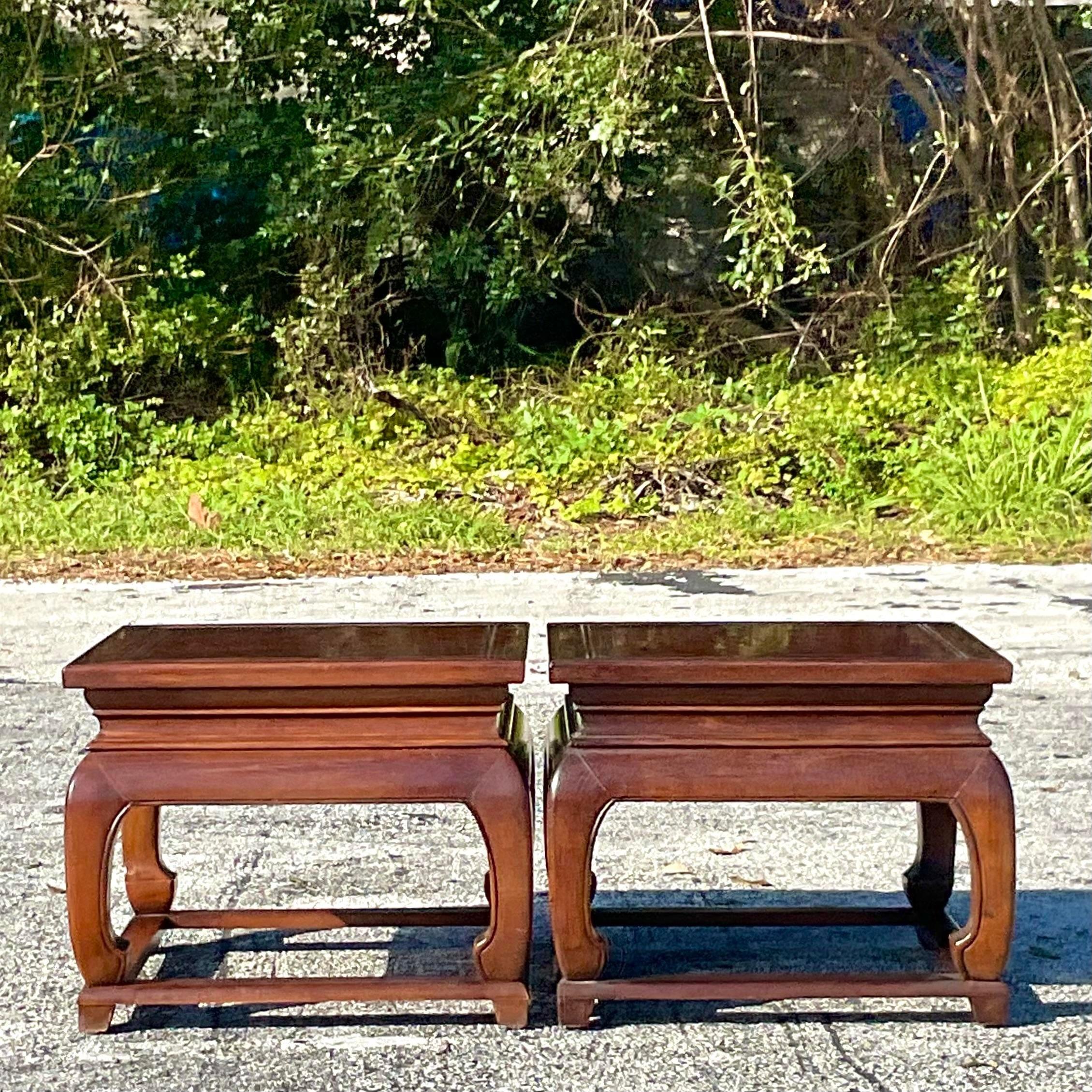 A fabulous pair of vintage Regency drinks tables. Made by the iconic Baker Furniture group and tagged on the bottom. A chic Burl wood construction with the classic Ming shape. Acquired from a Miami estate.