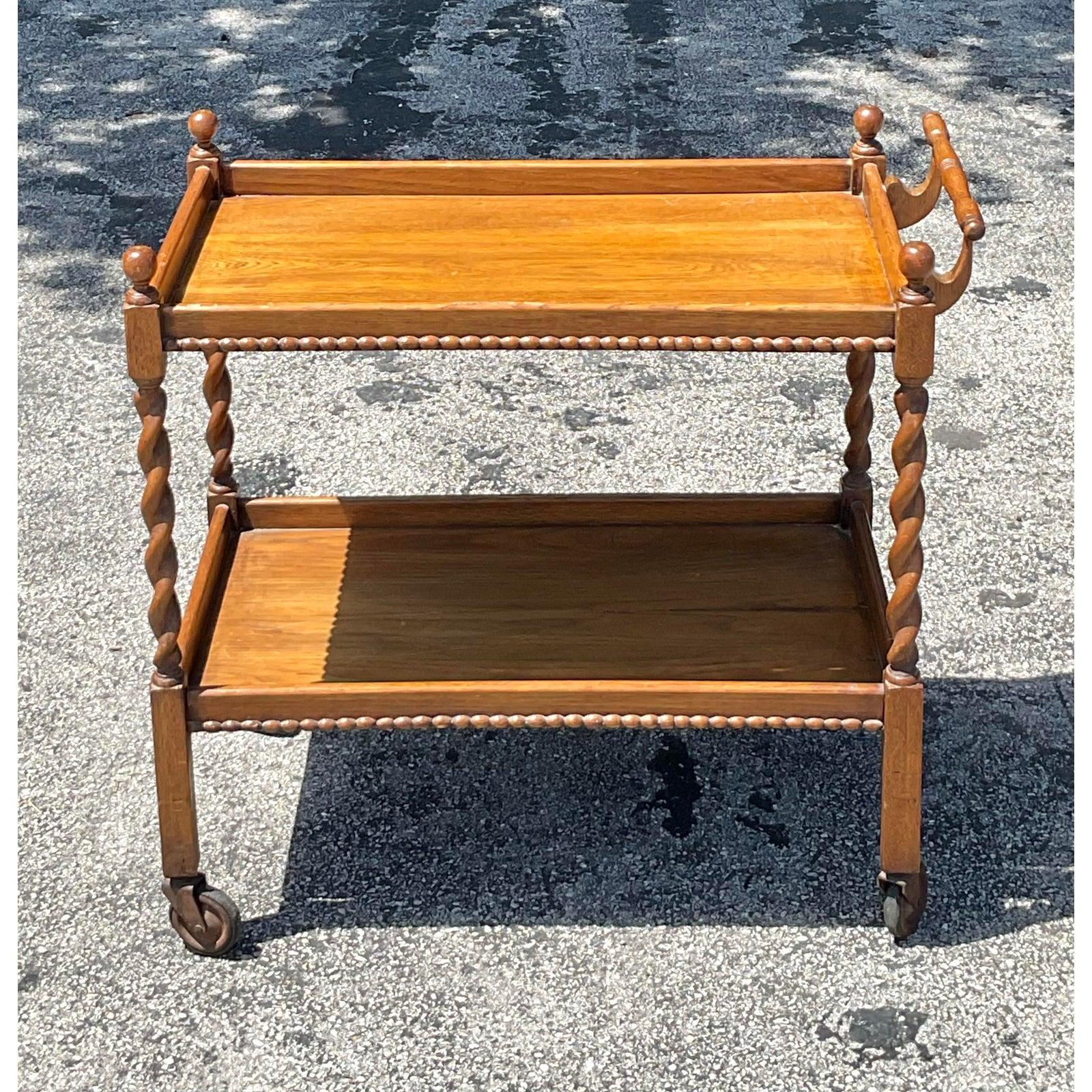 Bringen Sie einen Hauch von klassischer Raffinesse in Ihren Gastraum mit diesem wunderschön gearbeiteten Vintage Regency Barwagen. Mit seinen eleganten Beinen aus Gerstenkorn, den Kugelknäufen und der warmen Holzoberfläche bietet dieser zweistöckige